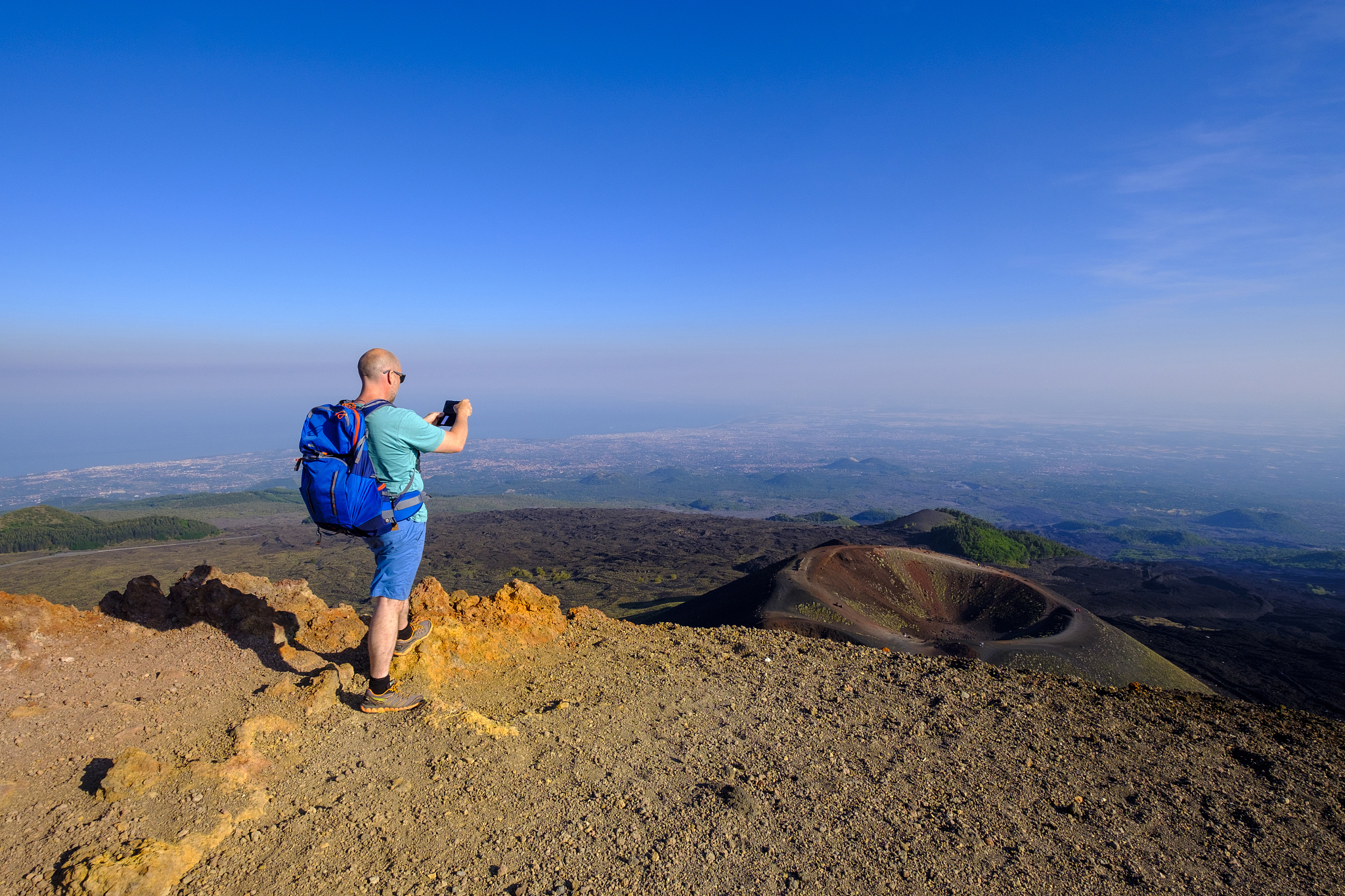 italy, sicily, mount etna, hiker photographing crater