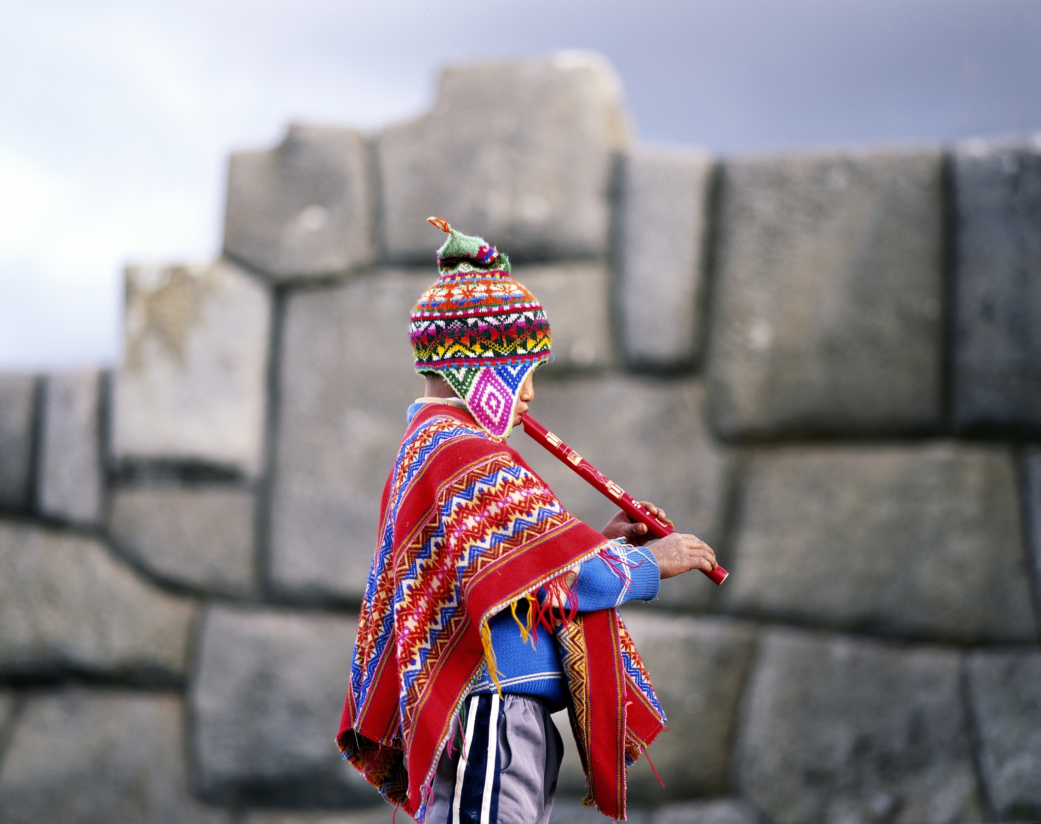 quechua indian boy playing flute, peru