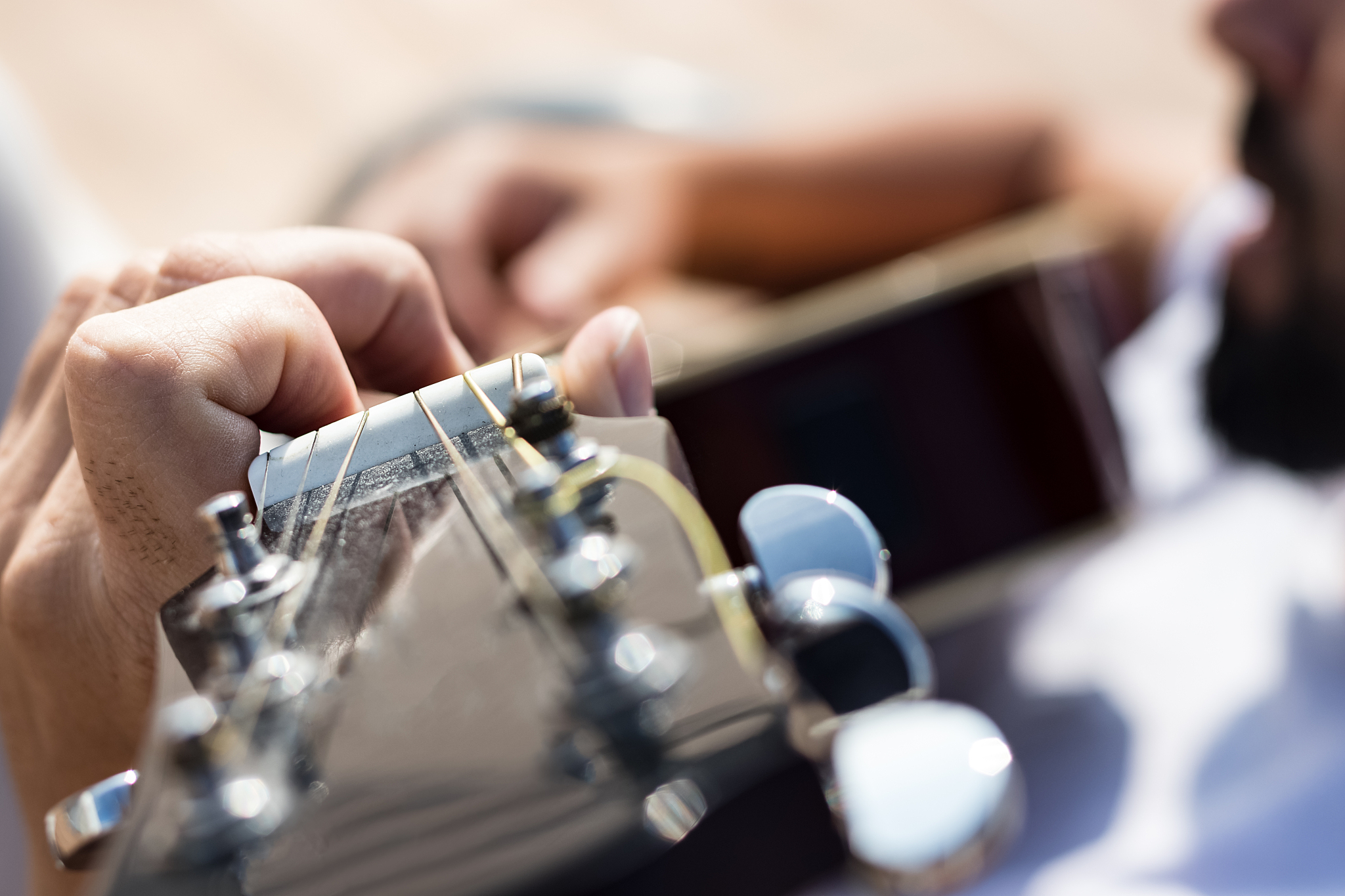 close up of the left hand of a guitarist playing chords.
