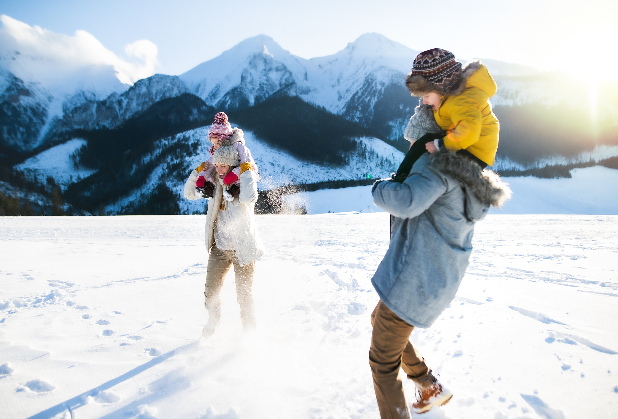 portrait of family with two small children enjoying snow in wint