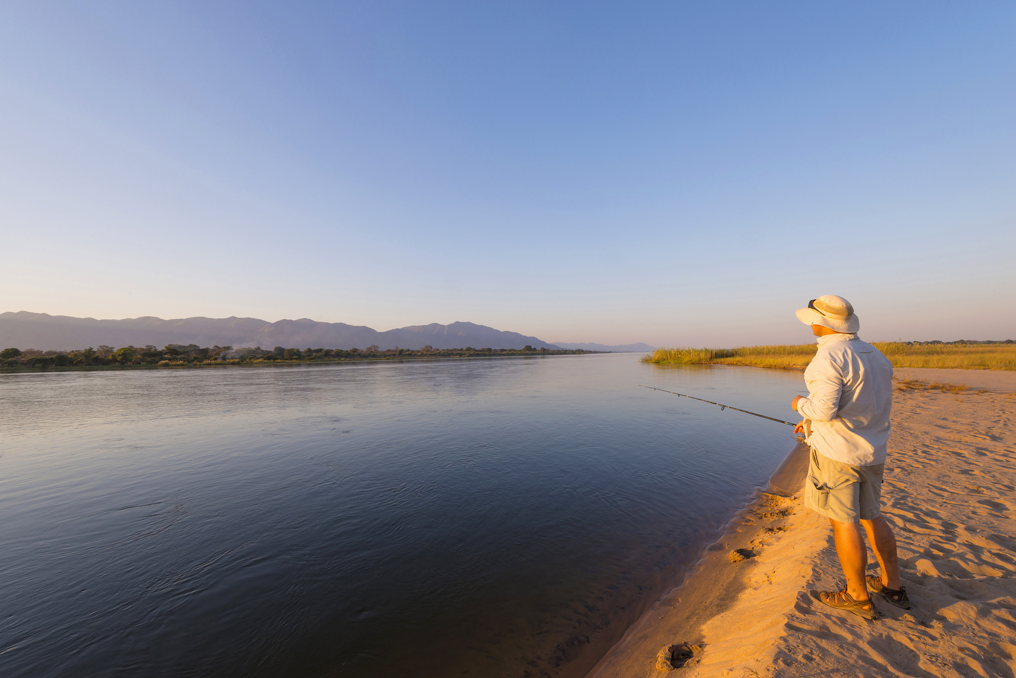 man fishing in river, mana pools national park, zimbabwe