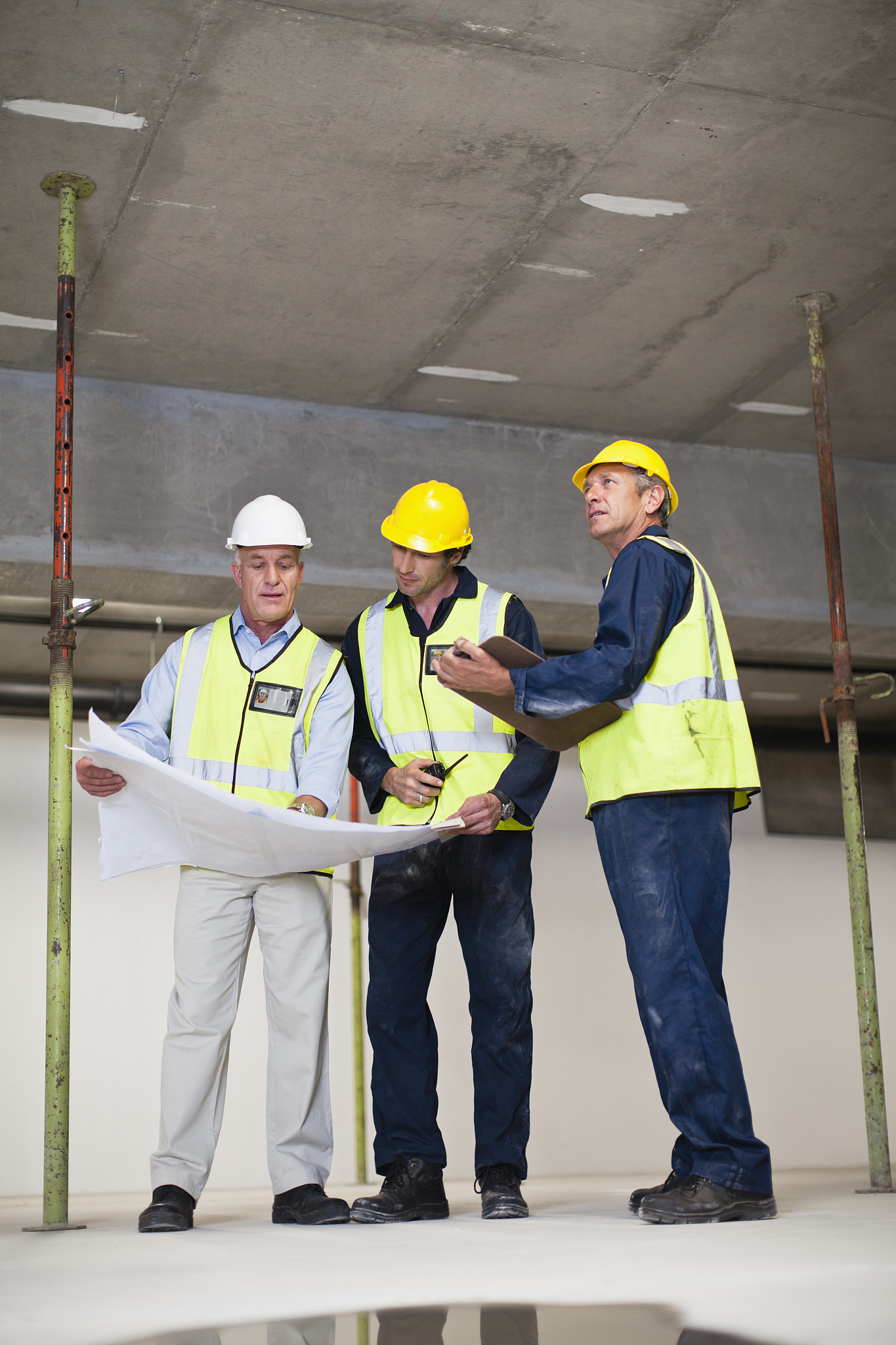 workers reading blueprints on site