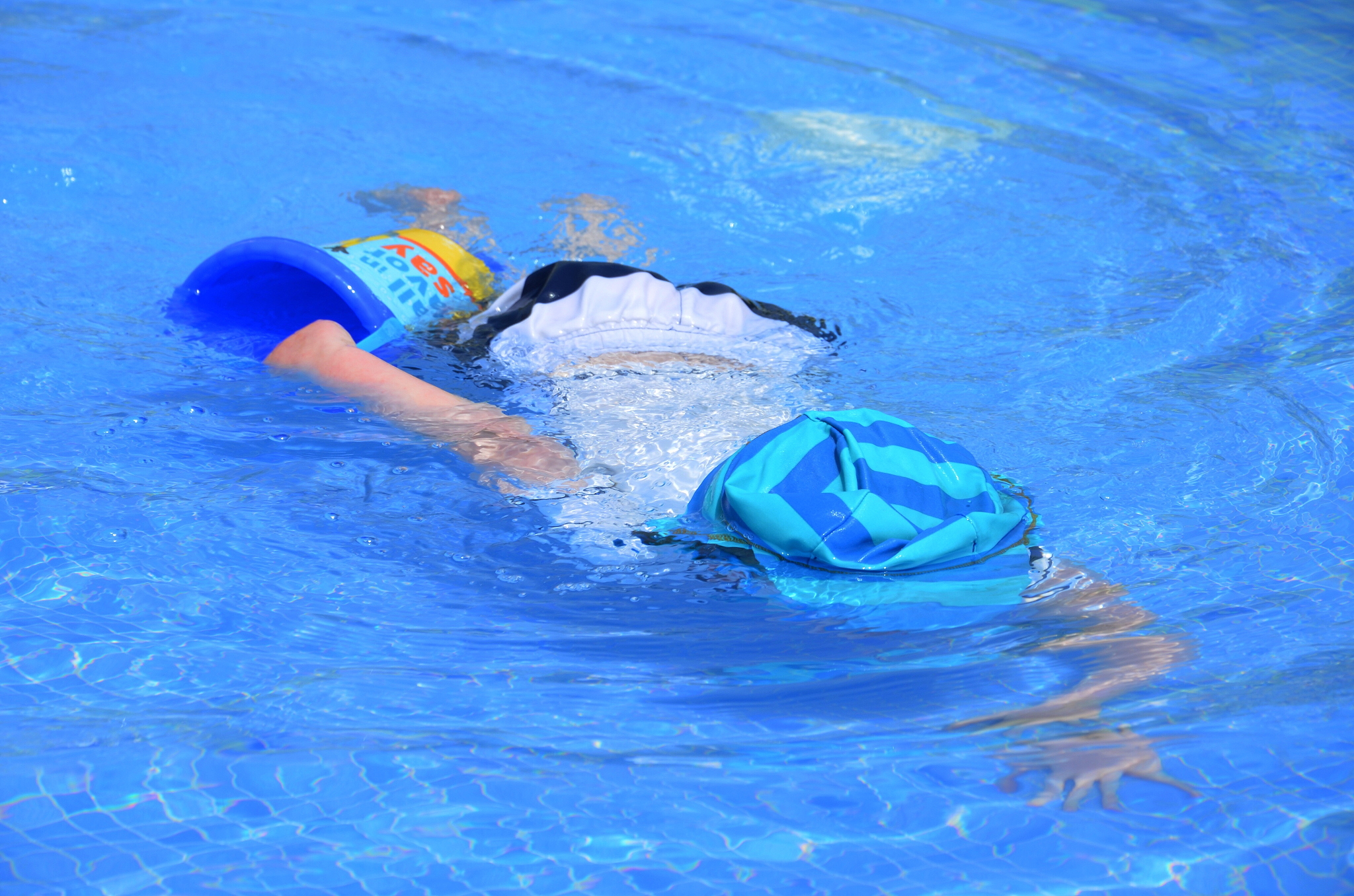 child swimming in pool