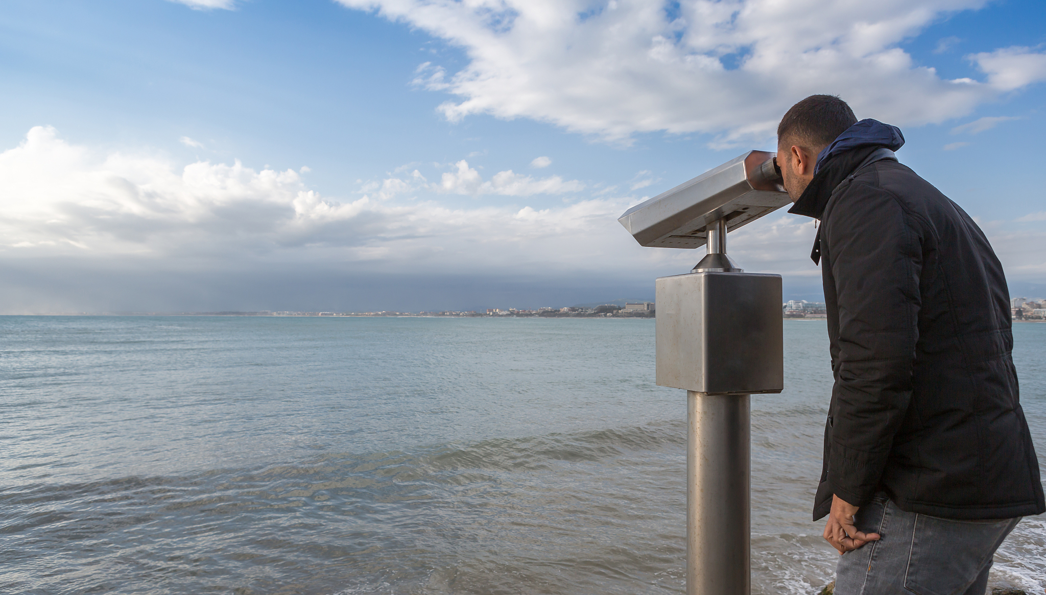 man looking through telescope