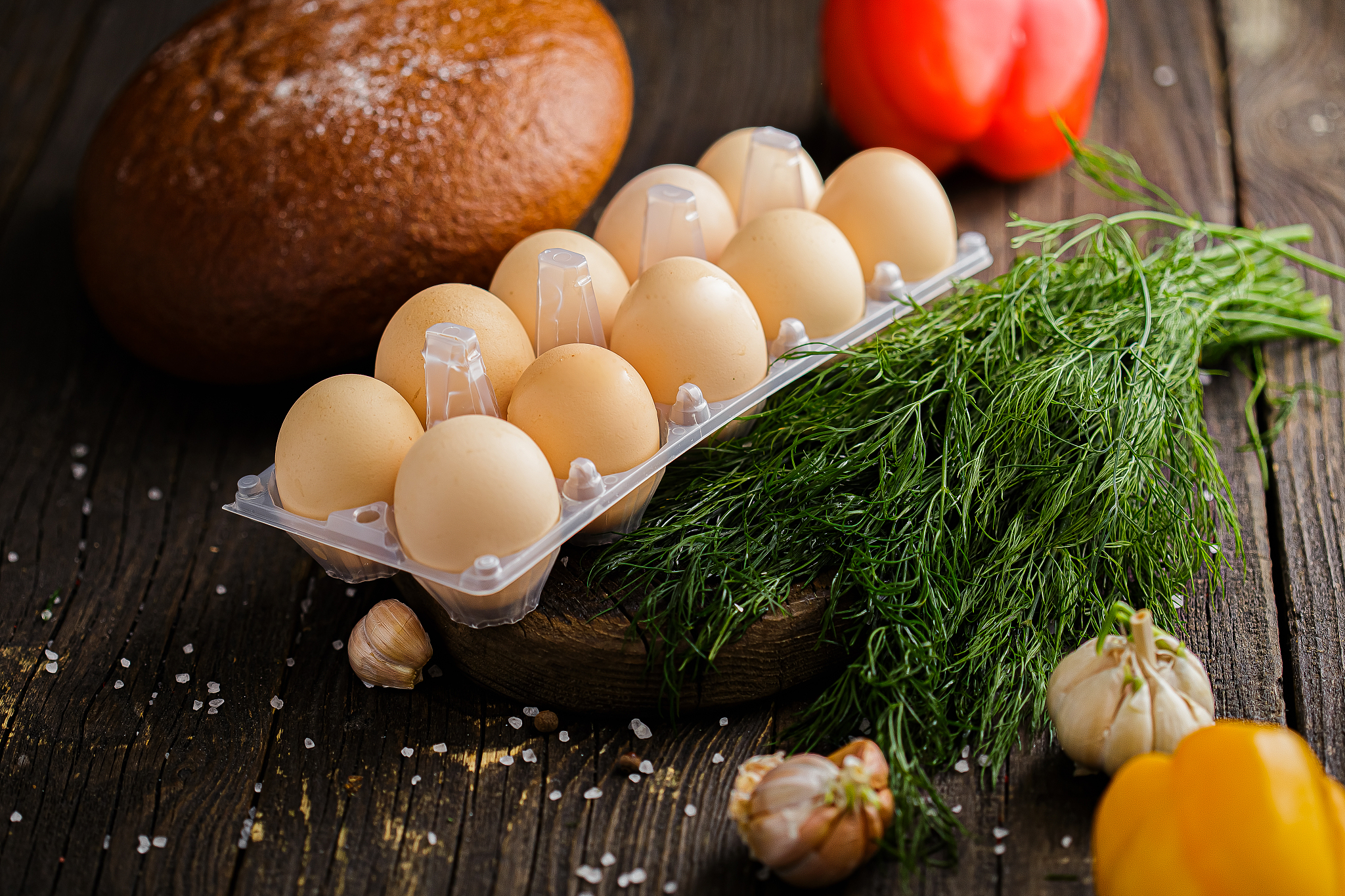 chicken eggs in a package on a wooden board, spices and coarse s