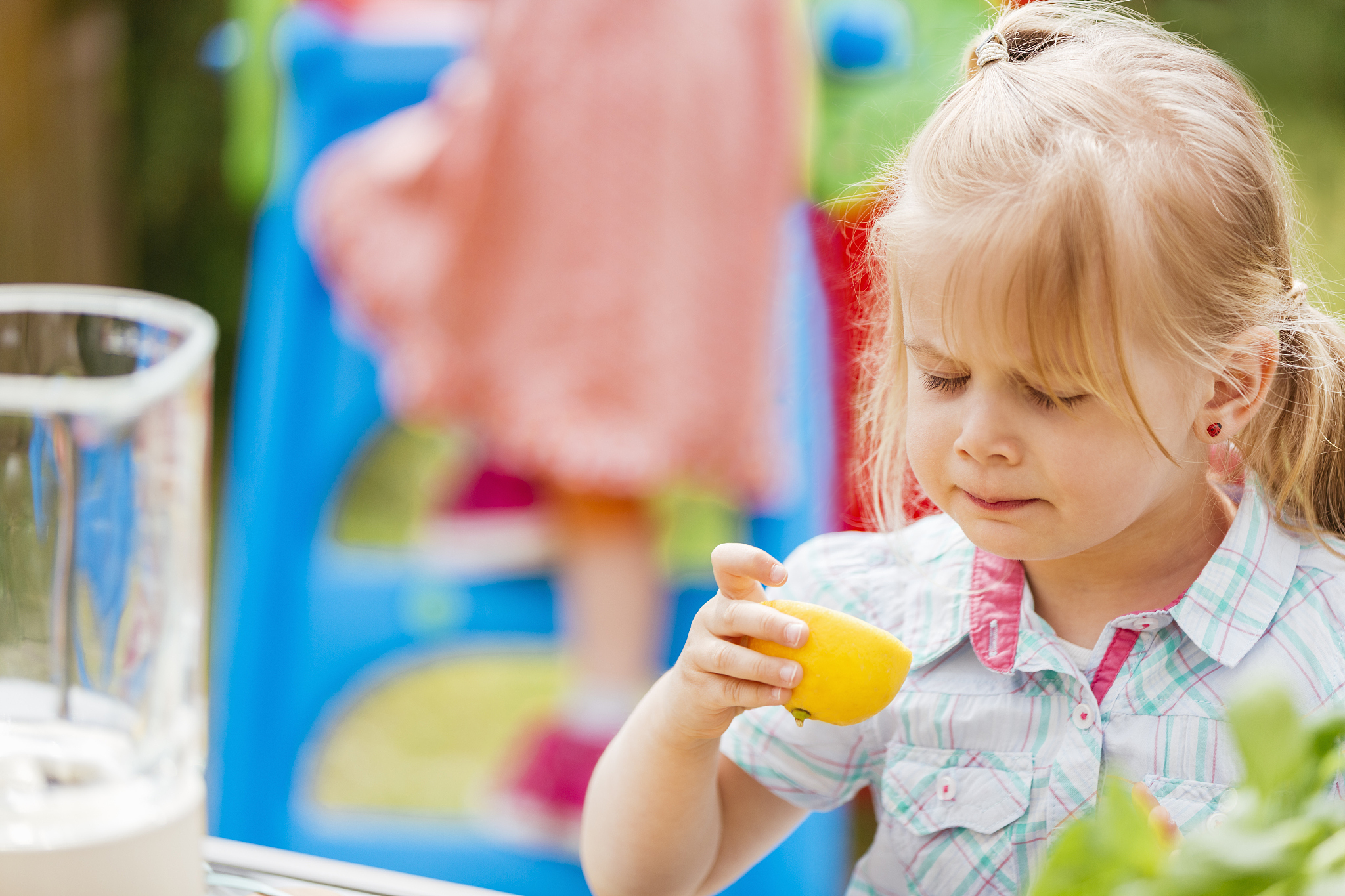 cute little girl tasting fresh lemon