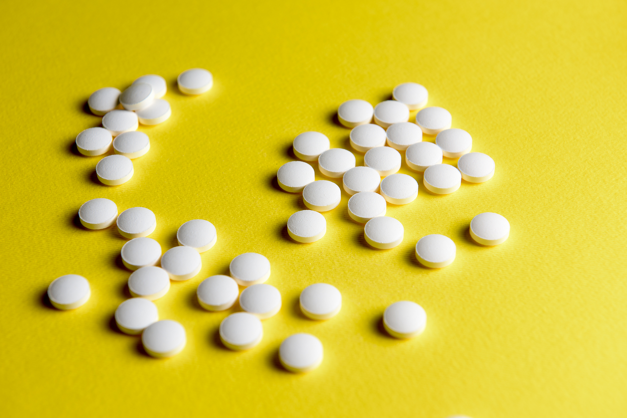 white pills on yellow background