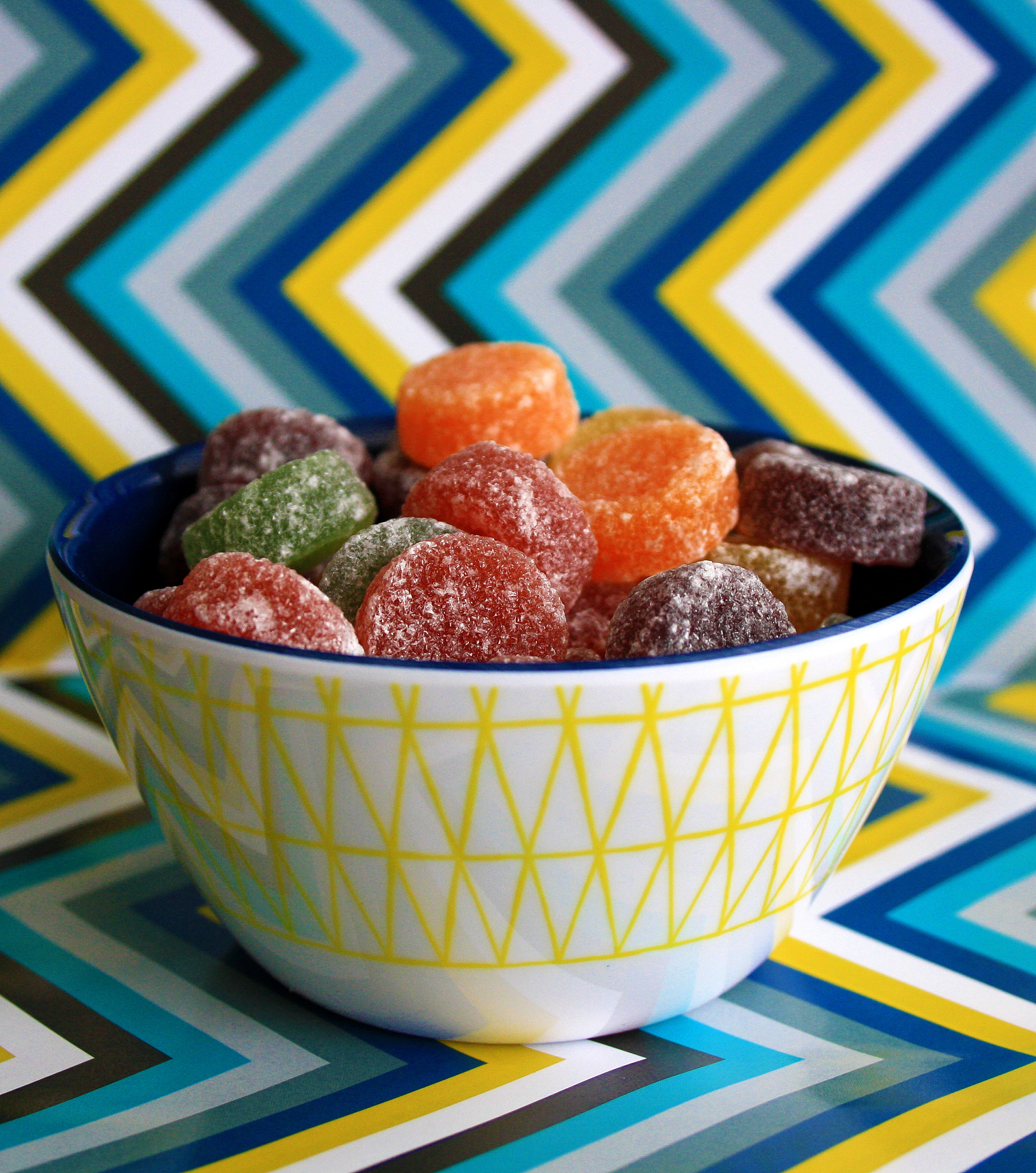 a colourful bowl of sweets/candy with a zigzag background