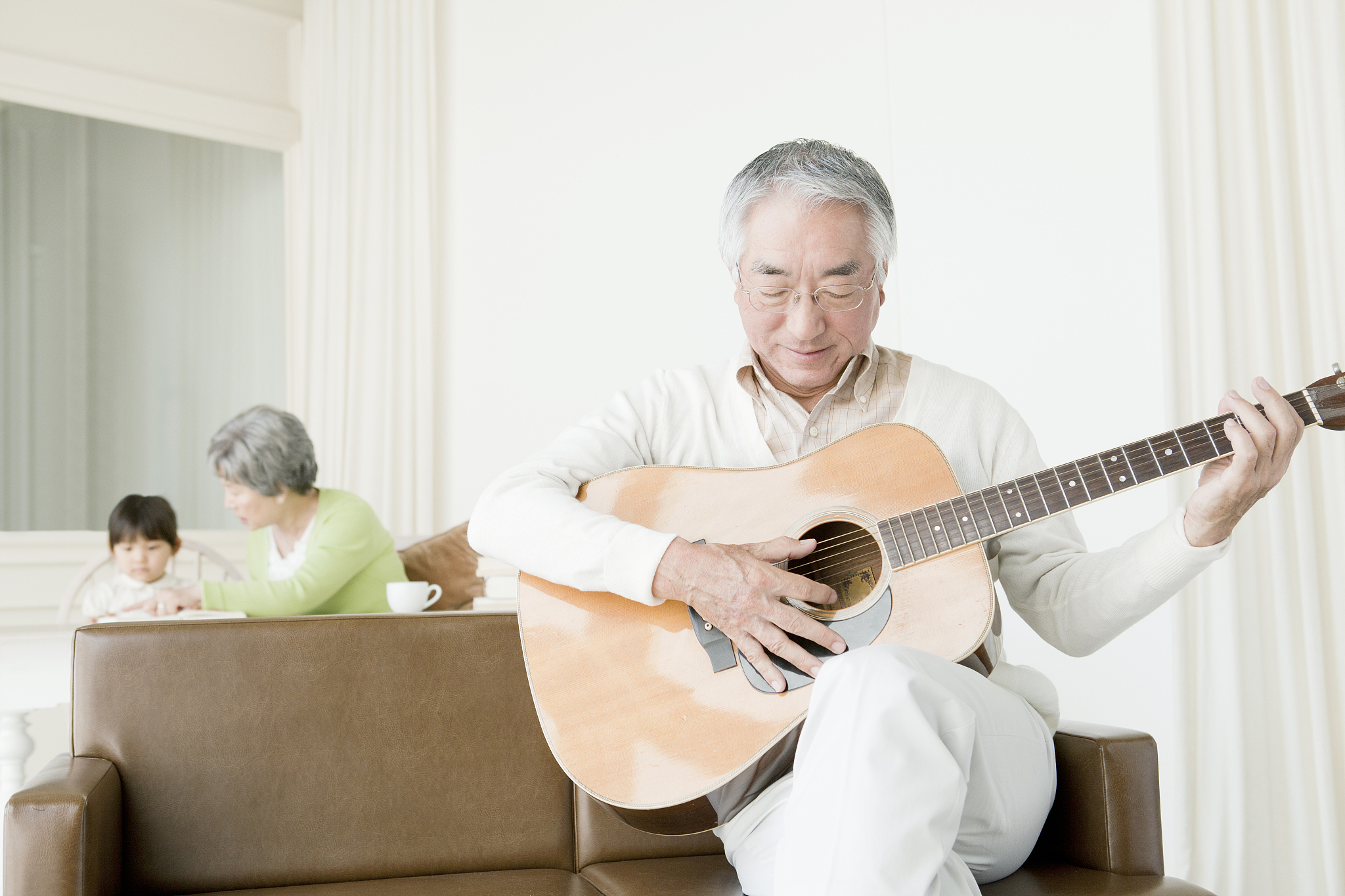 a senior man playing a guitar