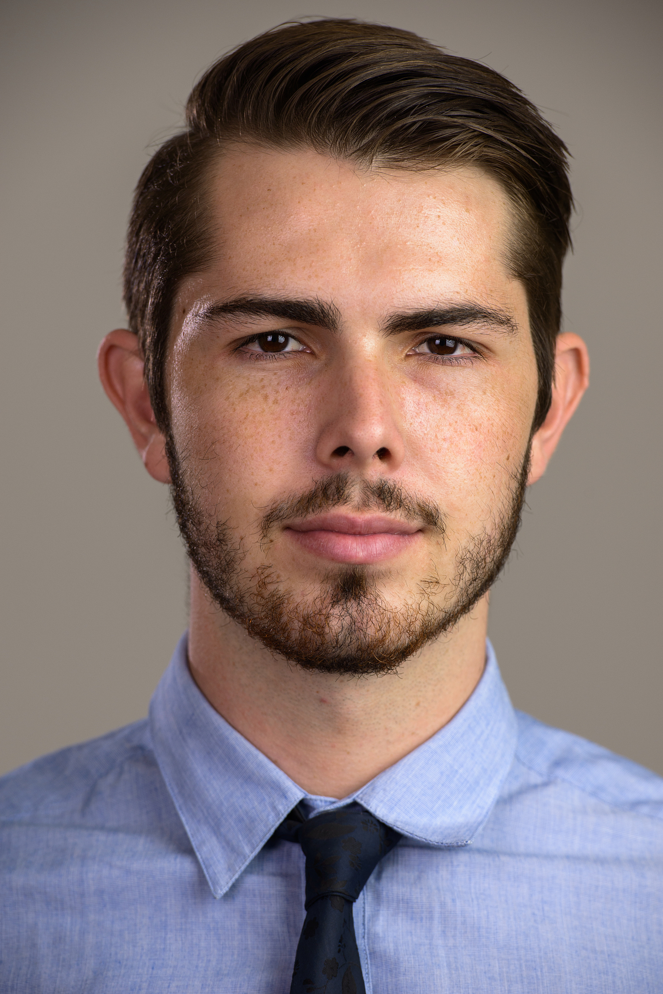 face of young handsome businessman against gray background