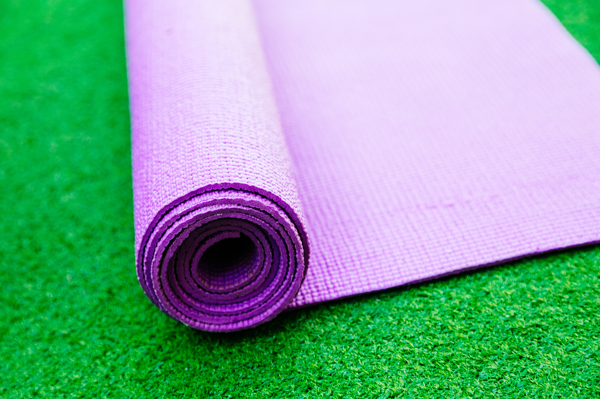 pink yoga mat on a green background
