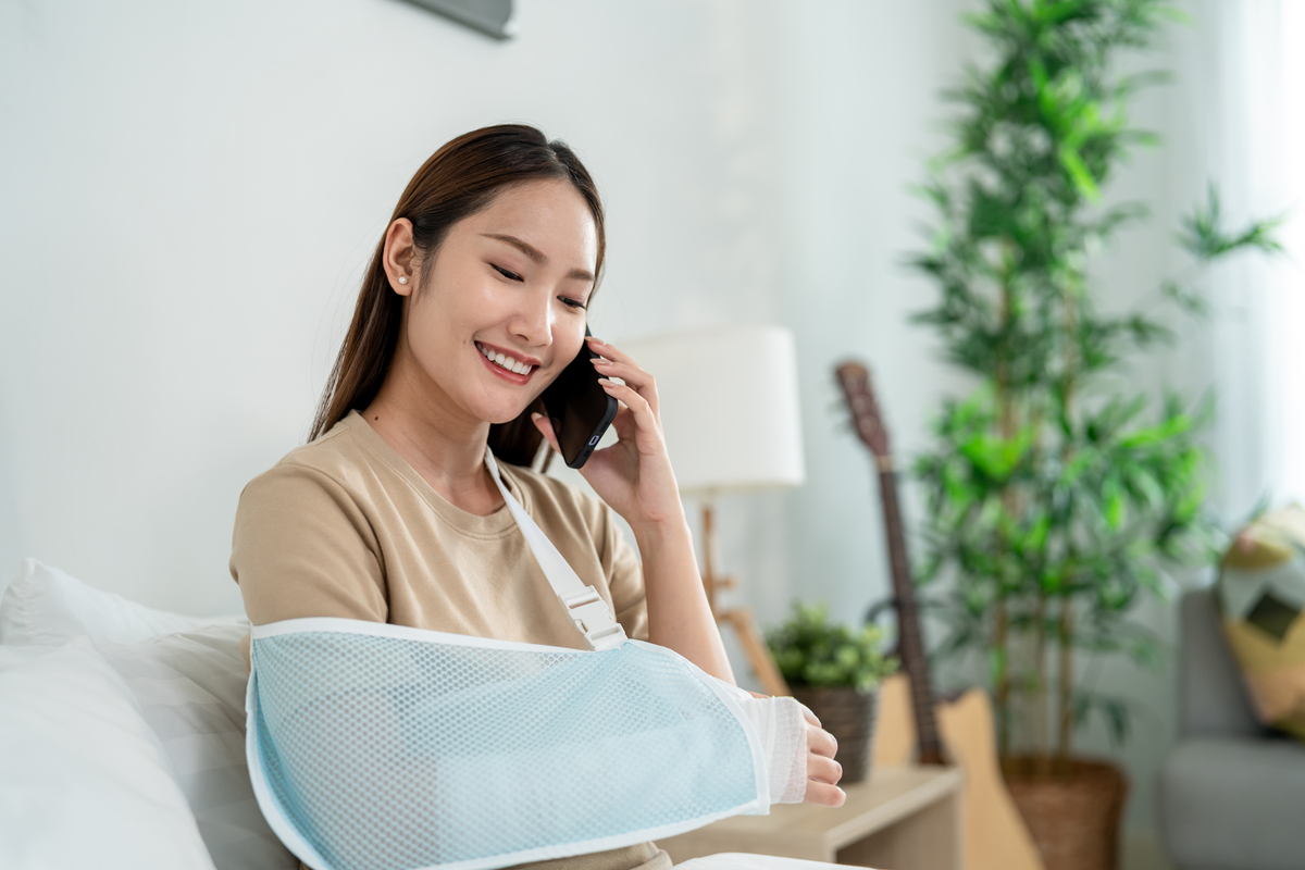 亚洲美女受伤在家卧室打电话.一位迷人的年轻女孩早上