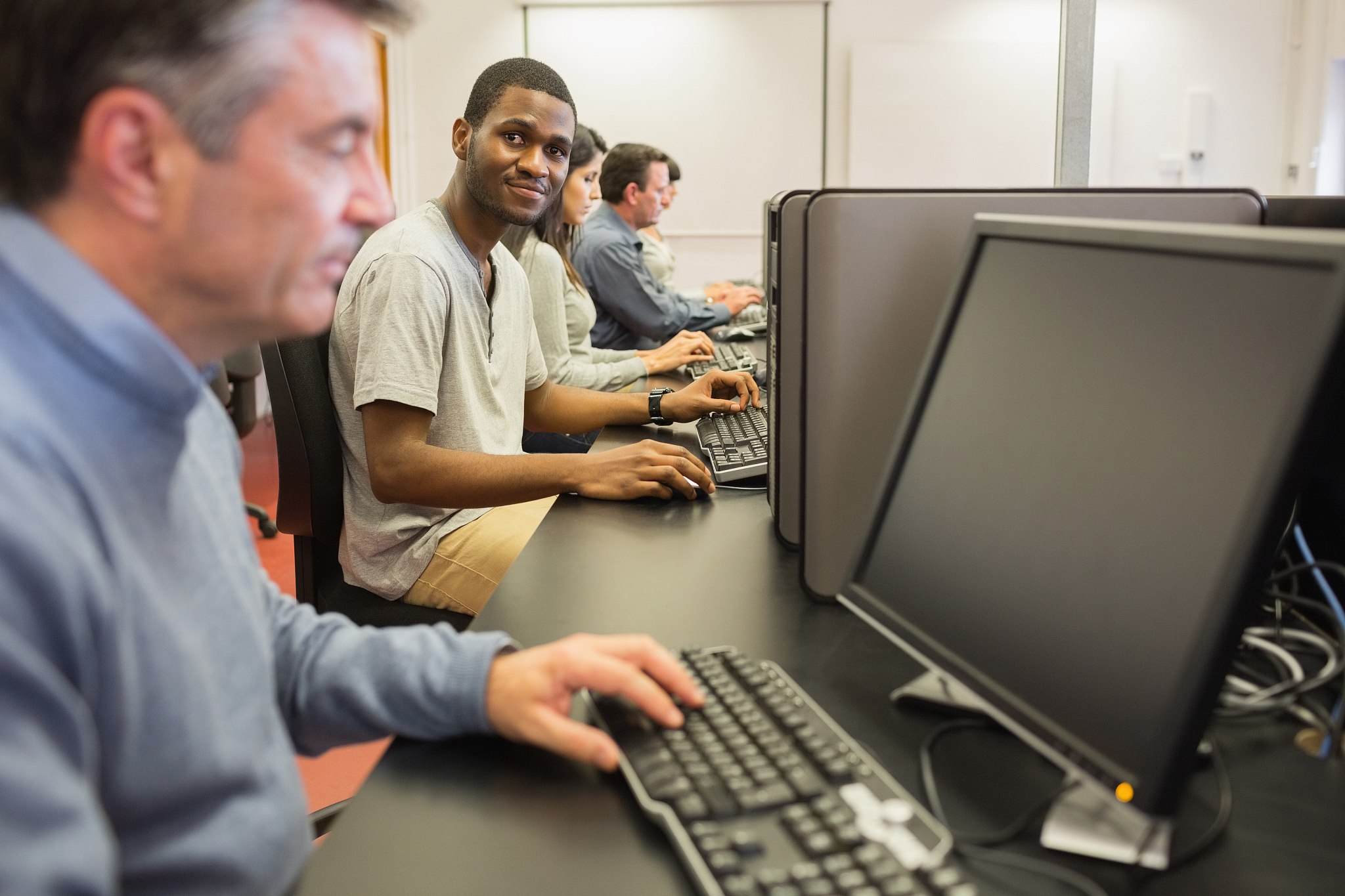 man looking up from computer class in college