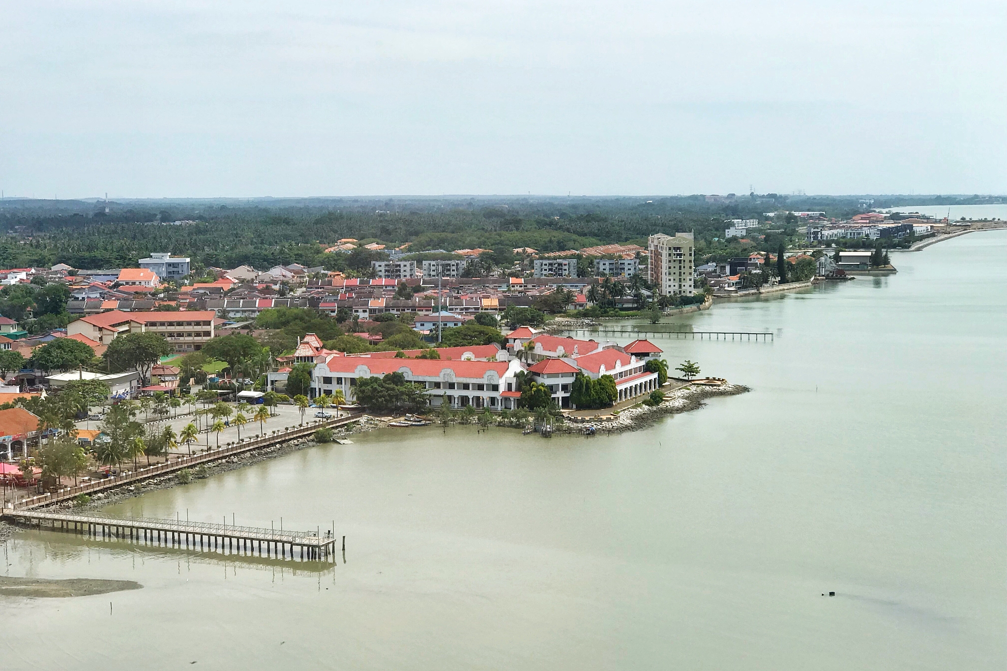 high angle view of buildings by river against sky