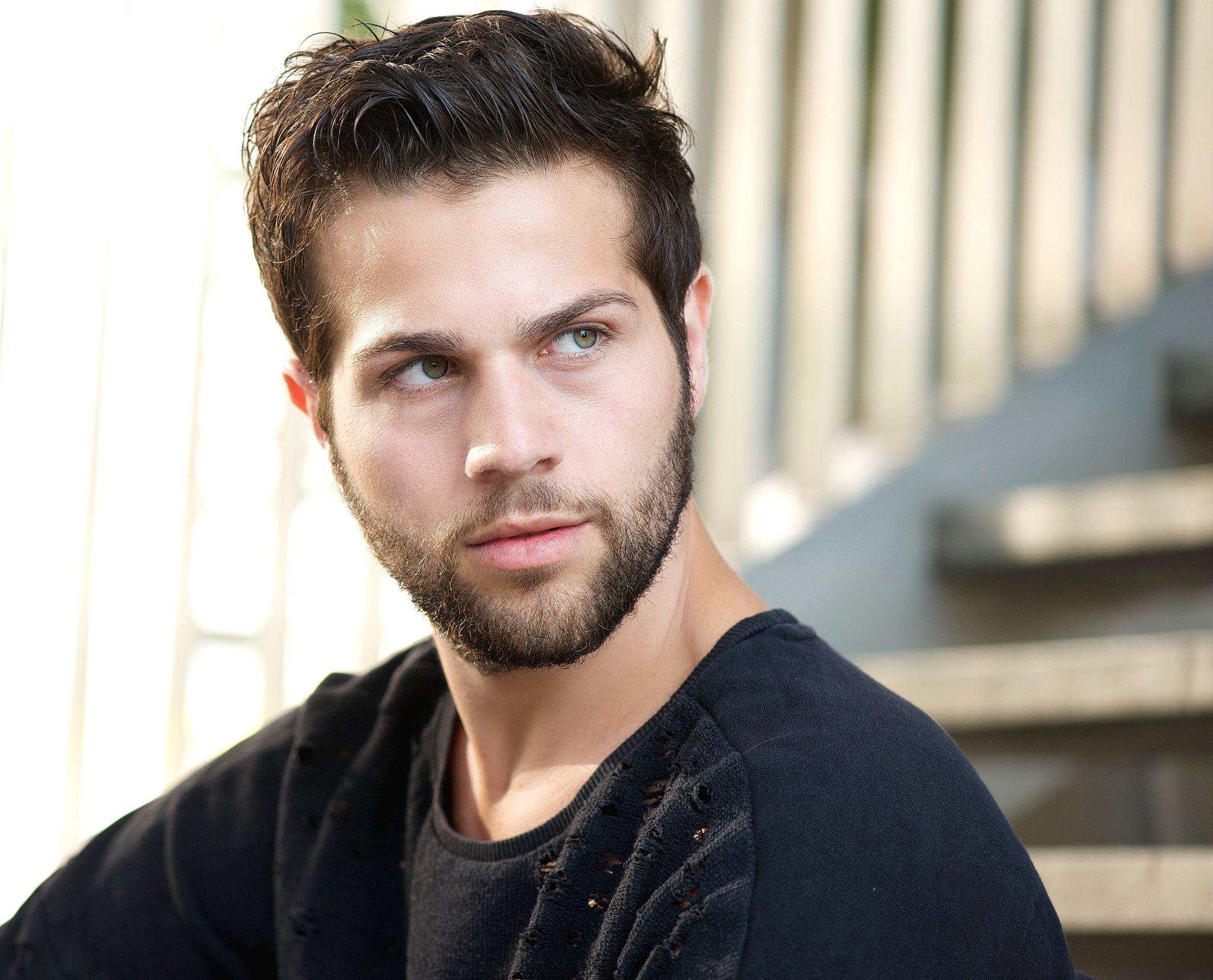 handsome young man with beard looking away