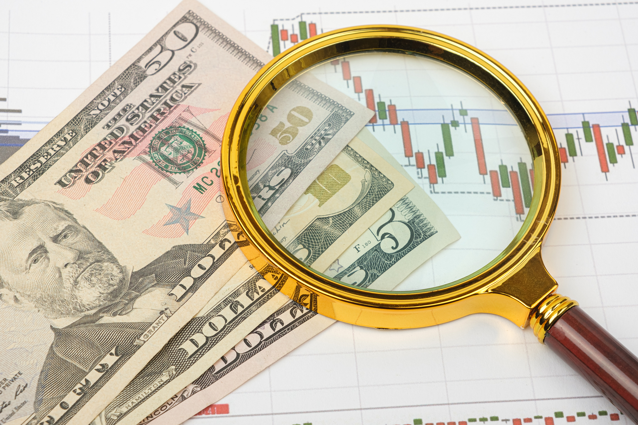 stock financing, money, economic charts and a magnifying glass. 
