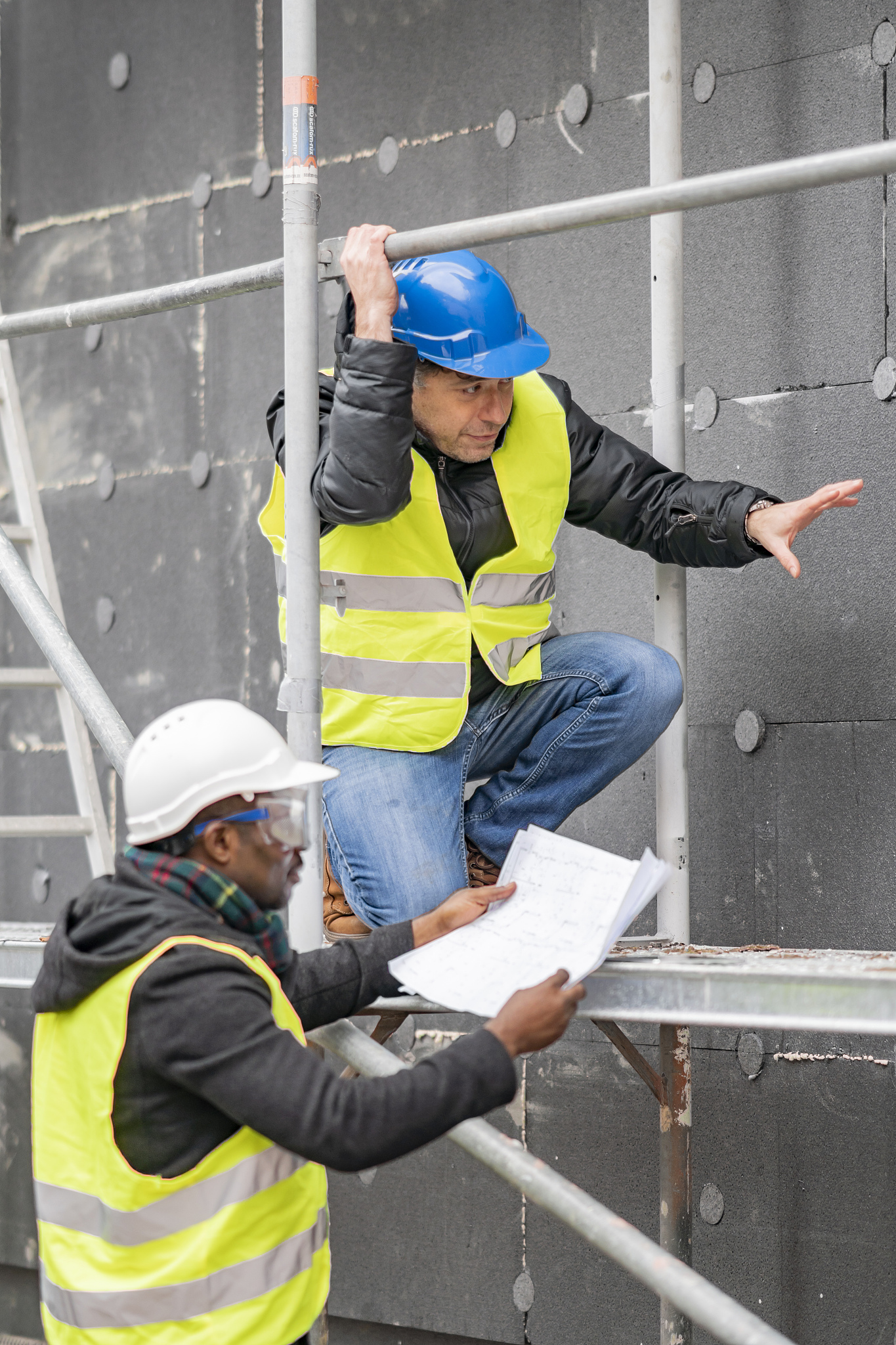 worker showing blueprint while working at construction site