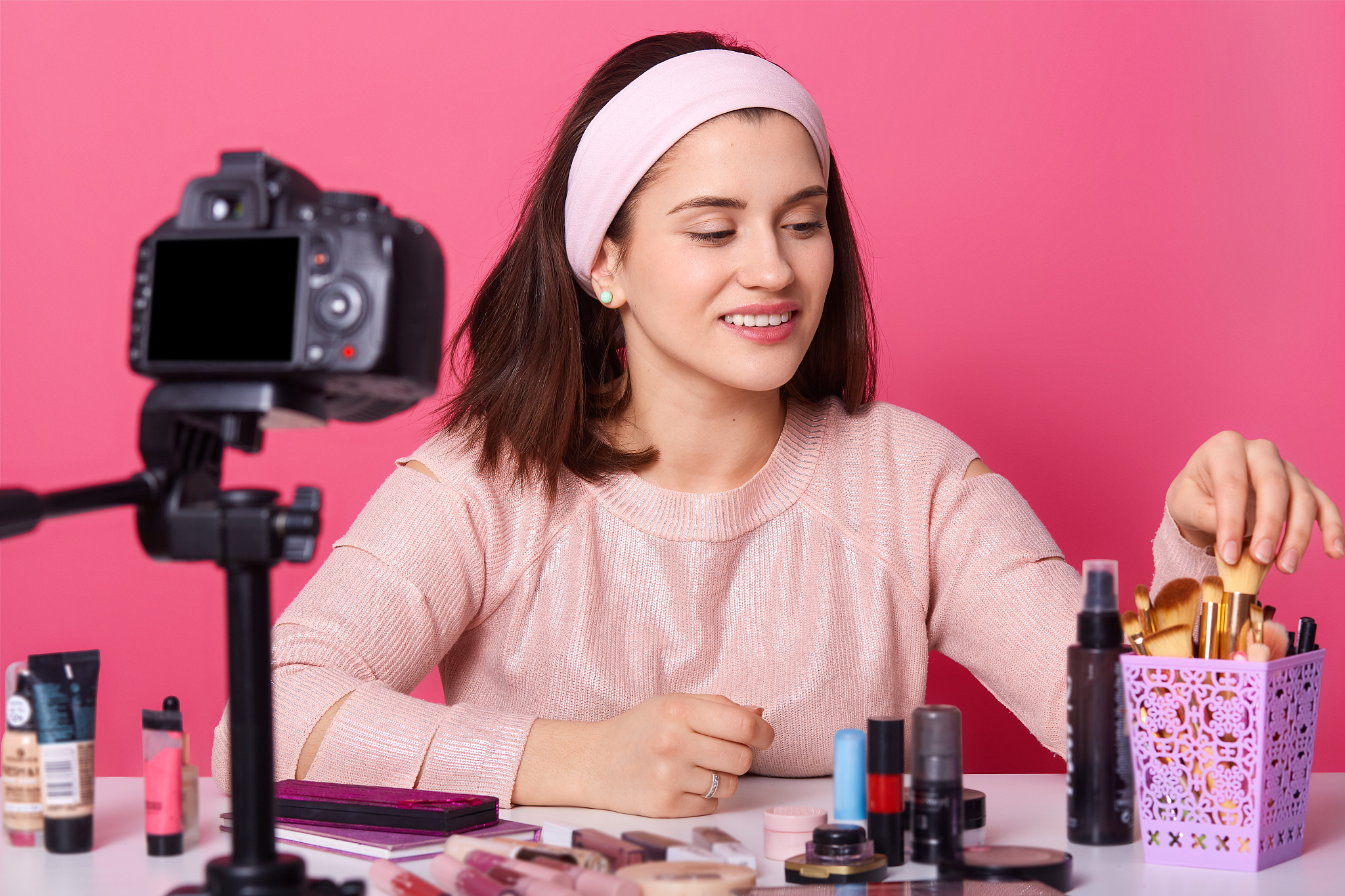 charming female blogger is showing cosmetics products while reco