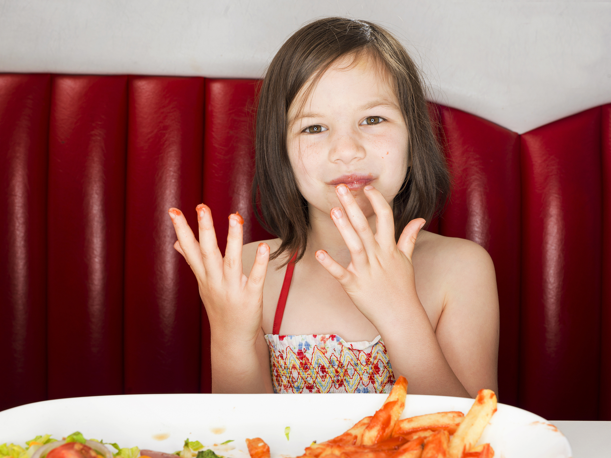girl licking her fingers after eating junk food
