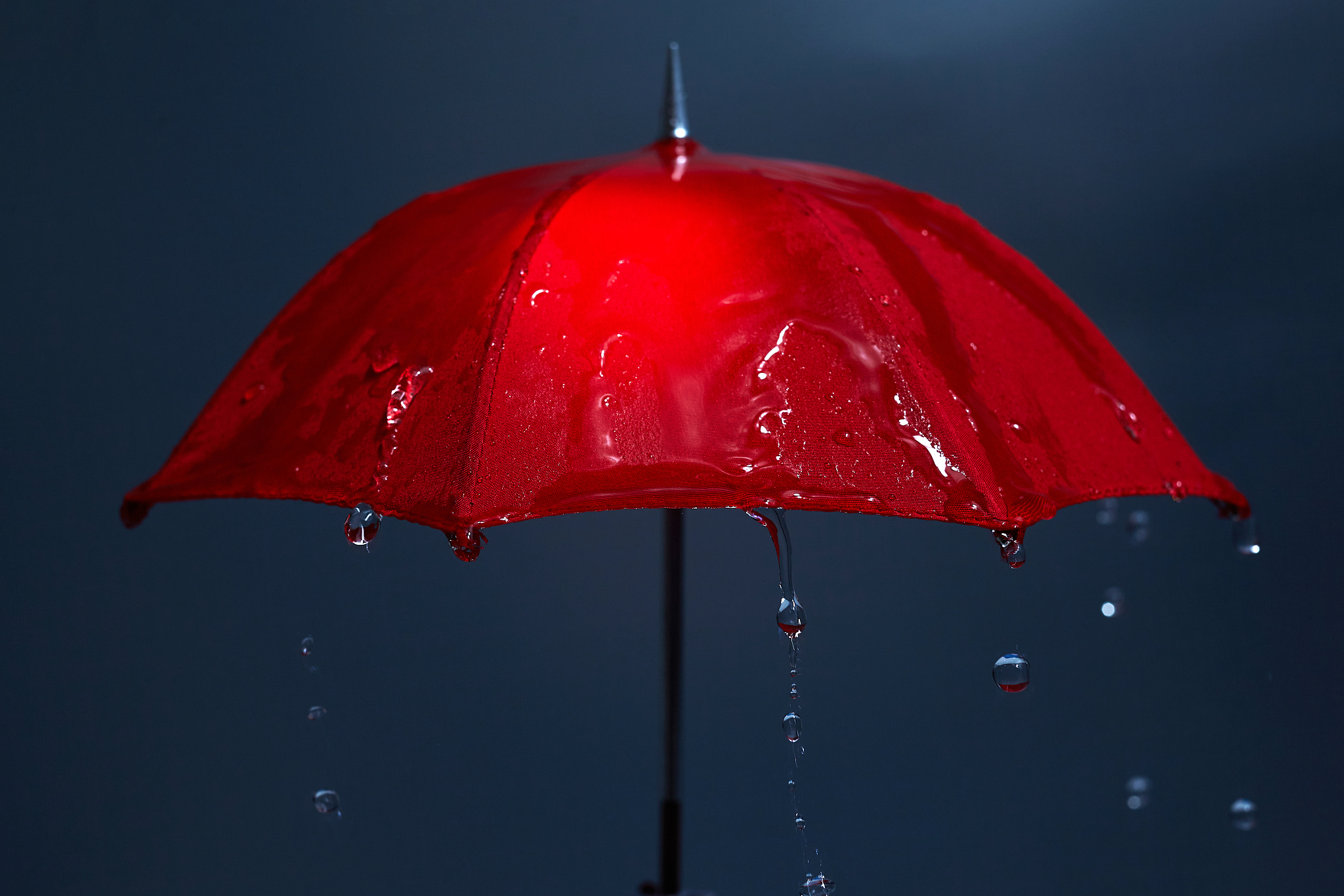 rain drops falling from red umbrella. bad weather concept.
