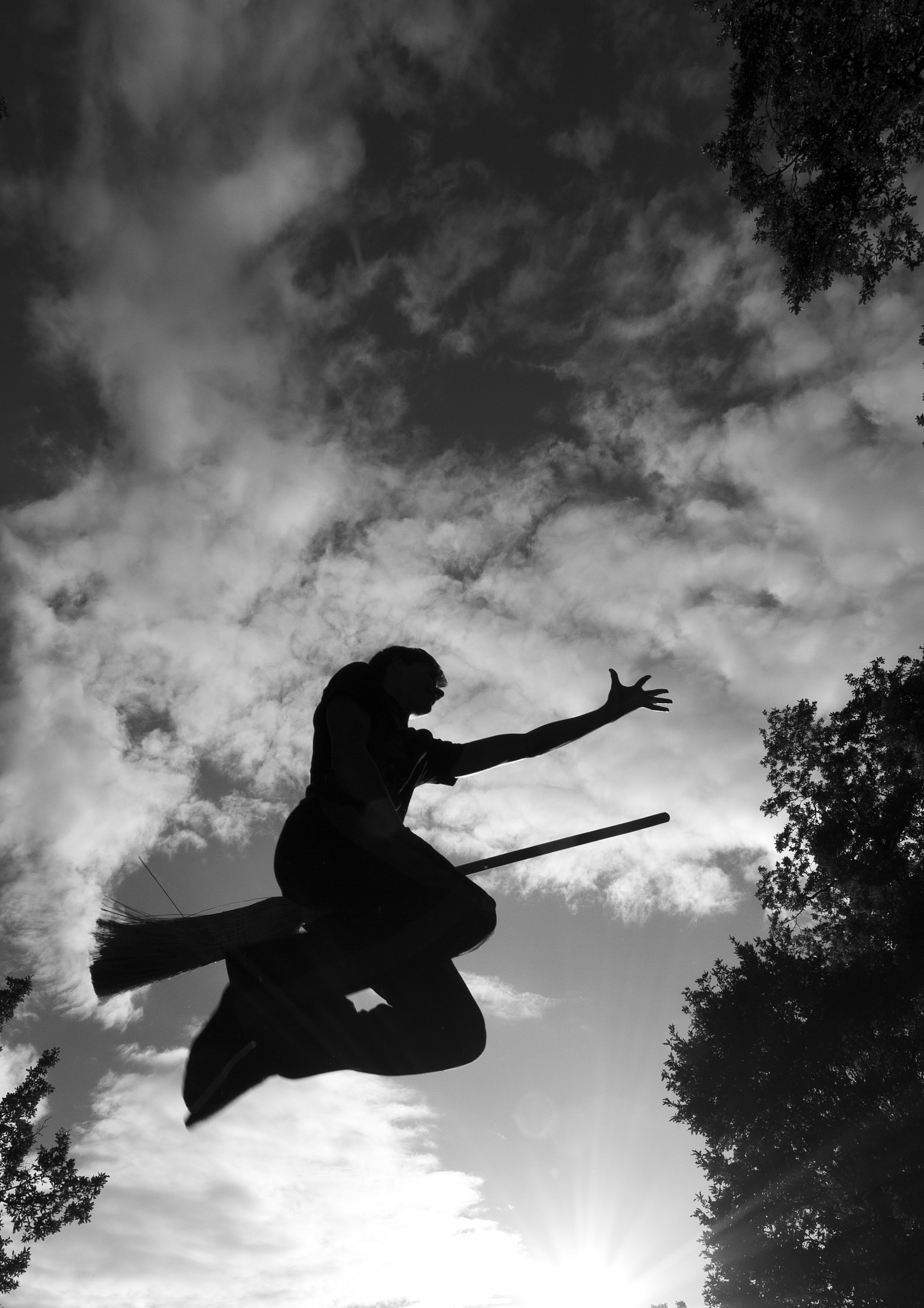 wizard boy silhouette flying on broom