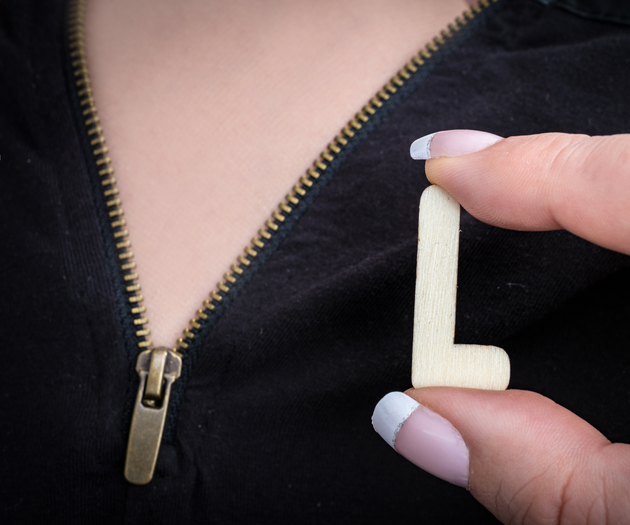 woman holds  size large  in front of open bronze zipper