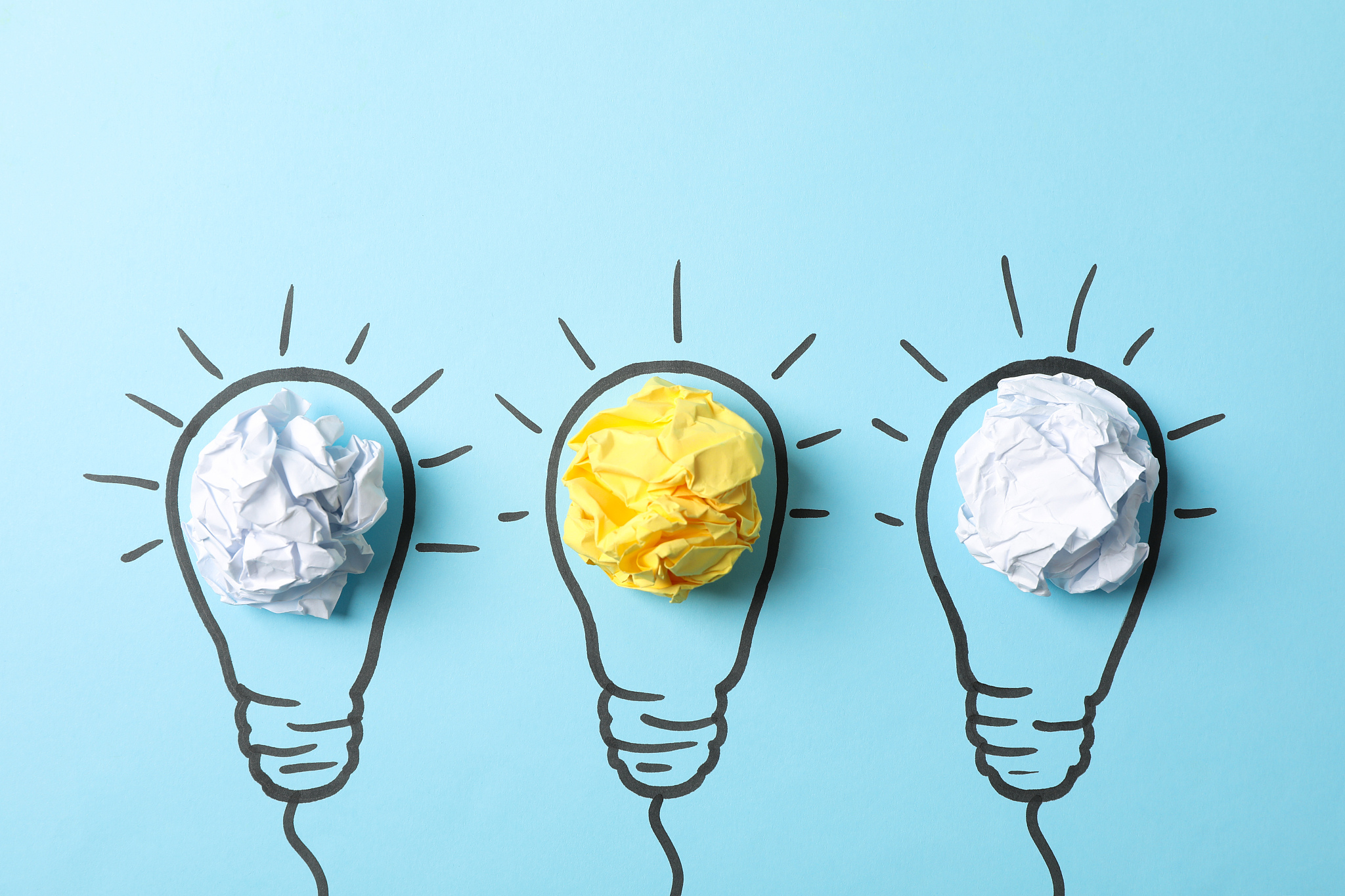 drawn light bulbs and paper balls on blue background, space for 