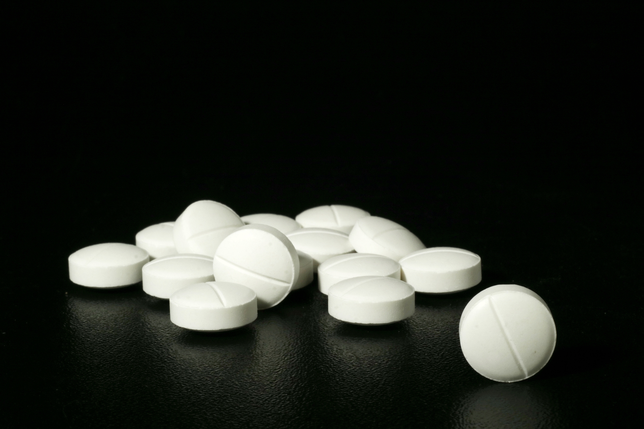 close-up of pills on table against black background
