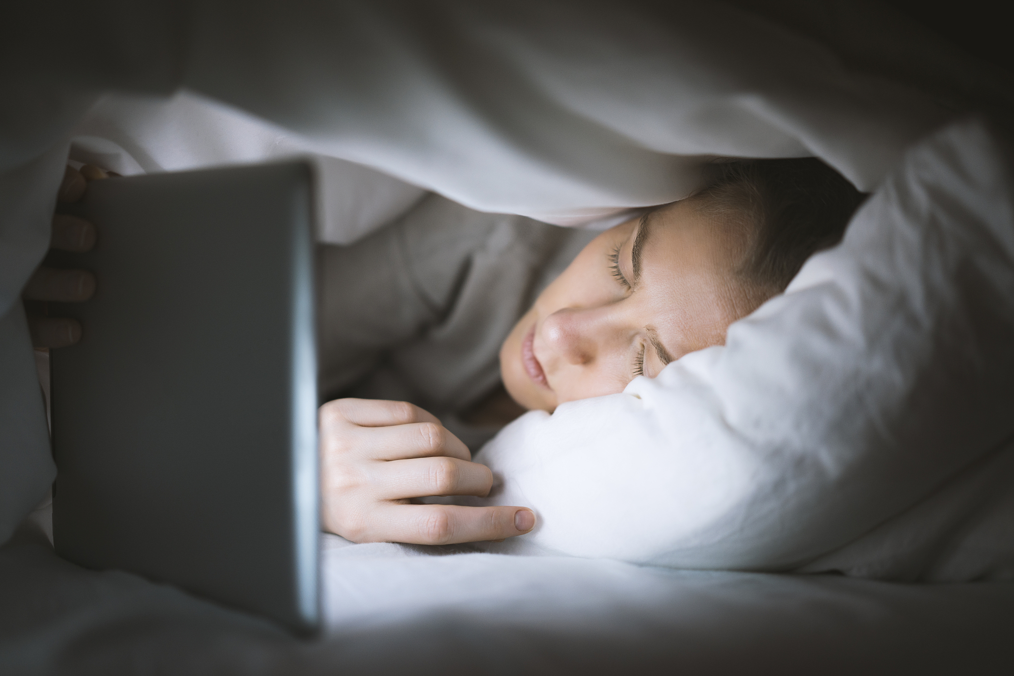 woman fall a sleep while using tablet pc in bed