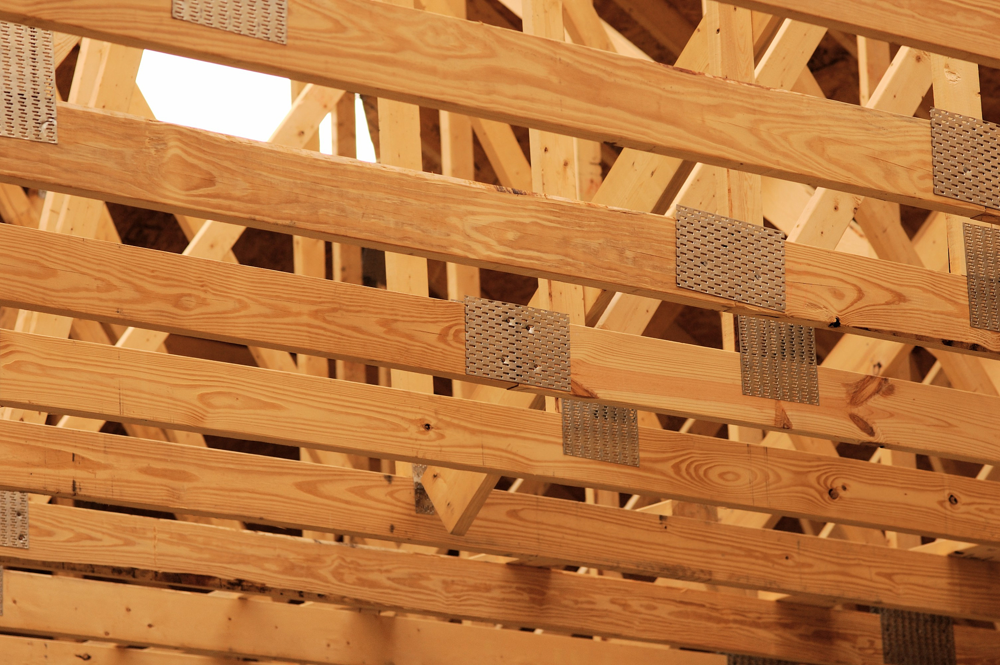 翻译这段话用于发表顶级SCI期刊论文要求符合母语者阅读习惯语气学术性其中重组竹的英文是bamboo scrimber：此外由于重组竹的弹性模量比较小其关键设计指标通常由挠度变形控制而且竹材的蠕变现象进一步增大了梁的变形使得重组竹材料的强度远未得到充分利用。因此我们需要研究重组竹梁的增强技术以提高其强度、承载力和截面刚度。