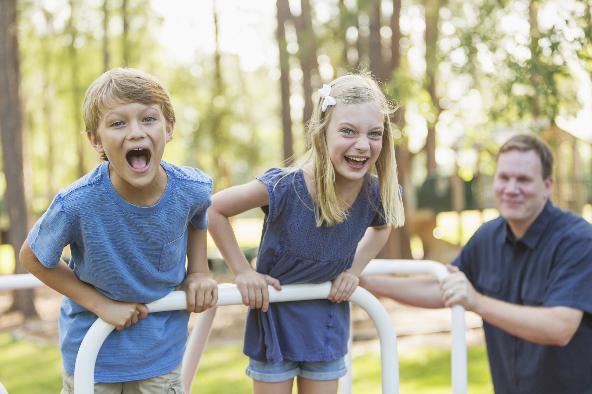 children with father playing on playground