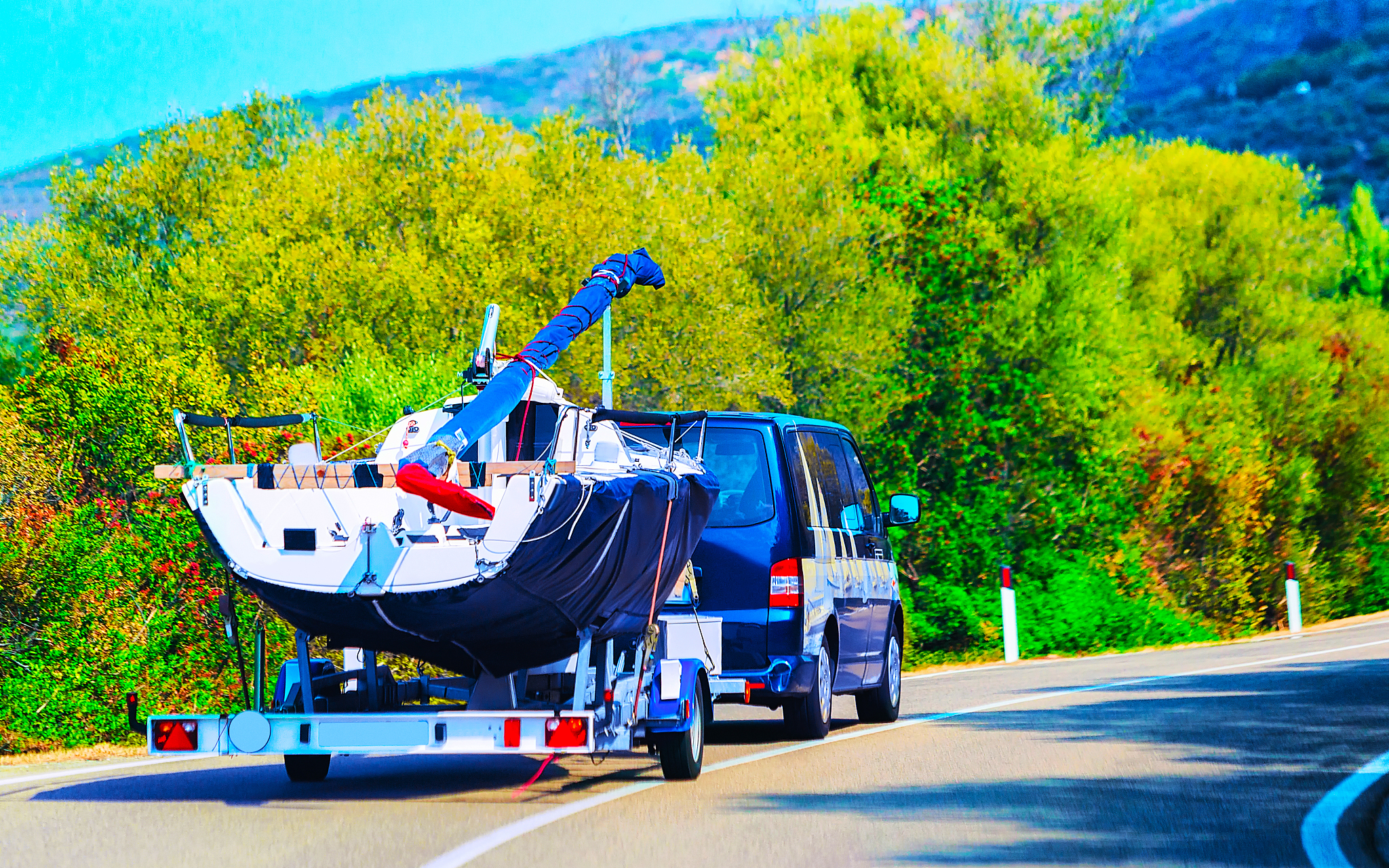 car with motor boat at trailer on road of olbia