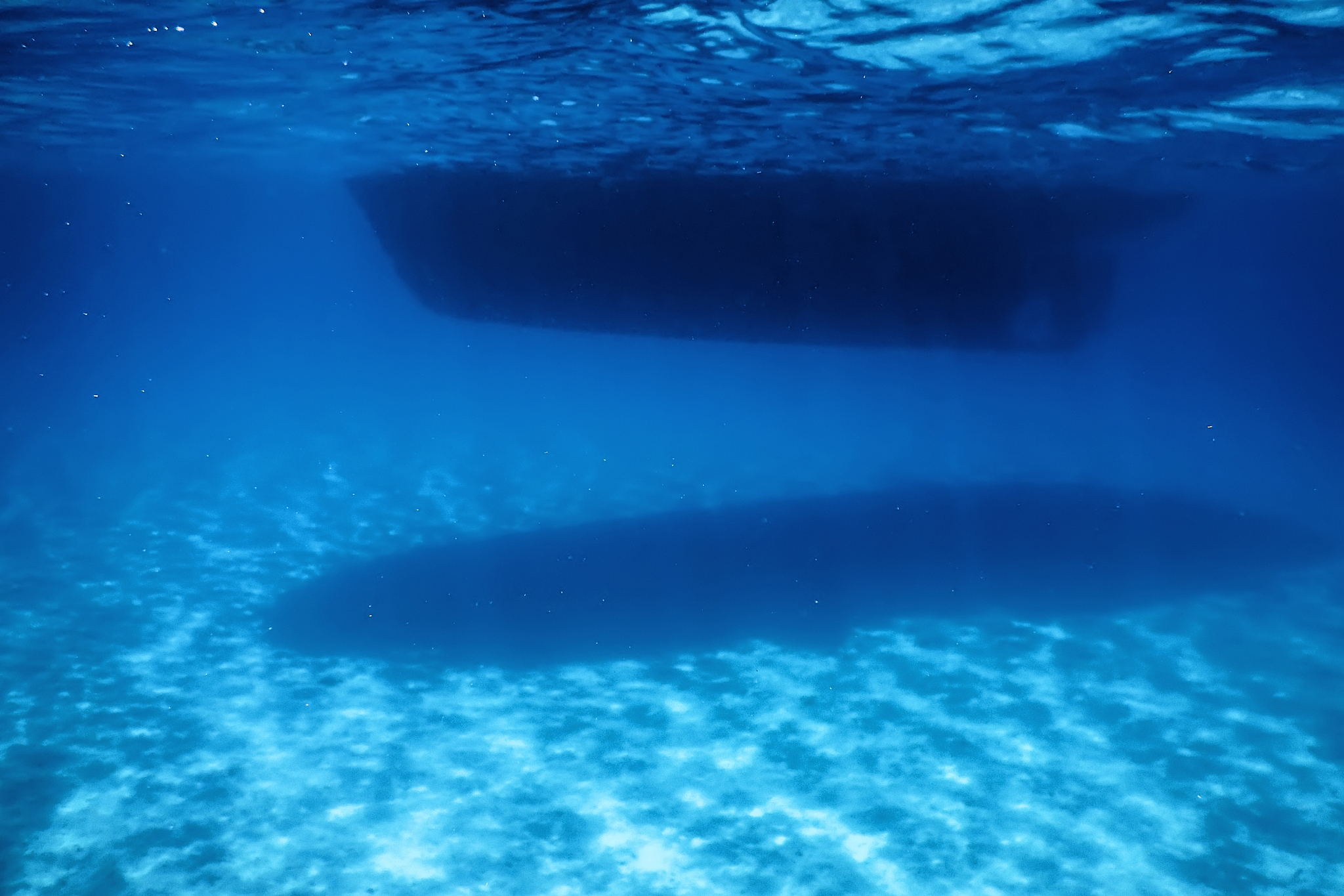 underwater view, bottom of a boat, sun shine beam and rays