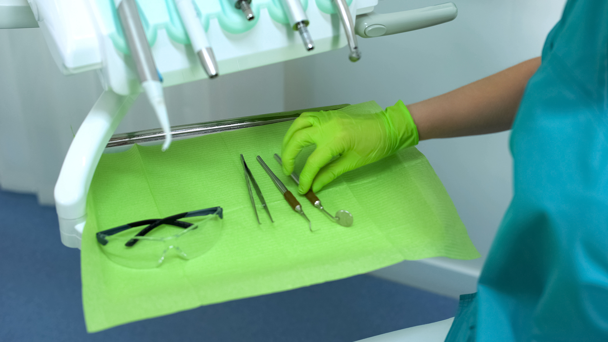 female dentist taking stomatology mirror, modern equipment in ne