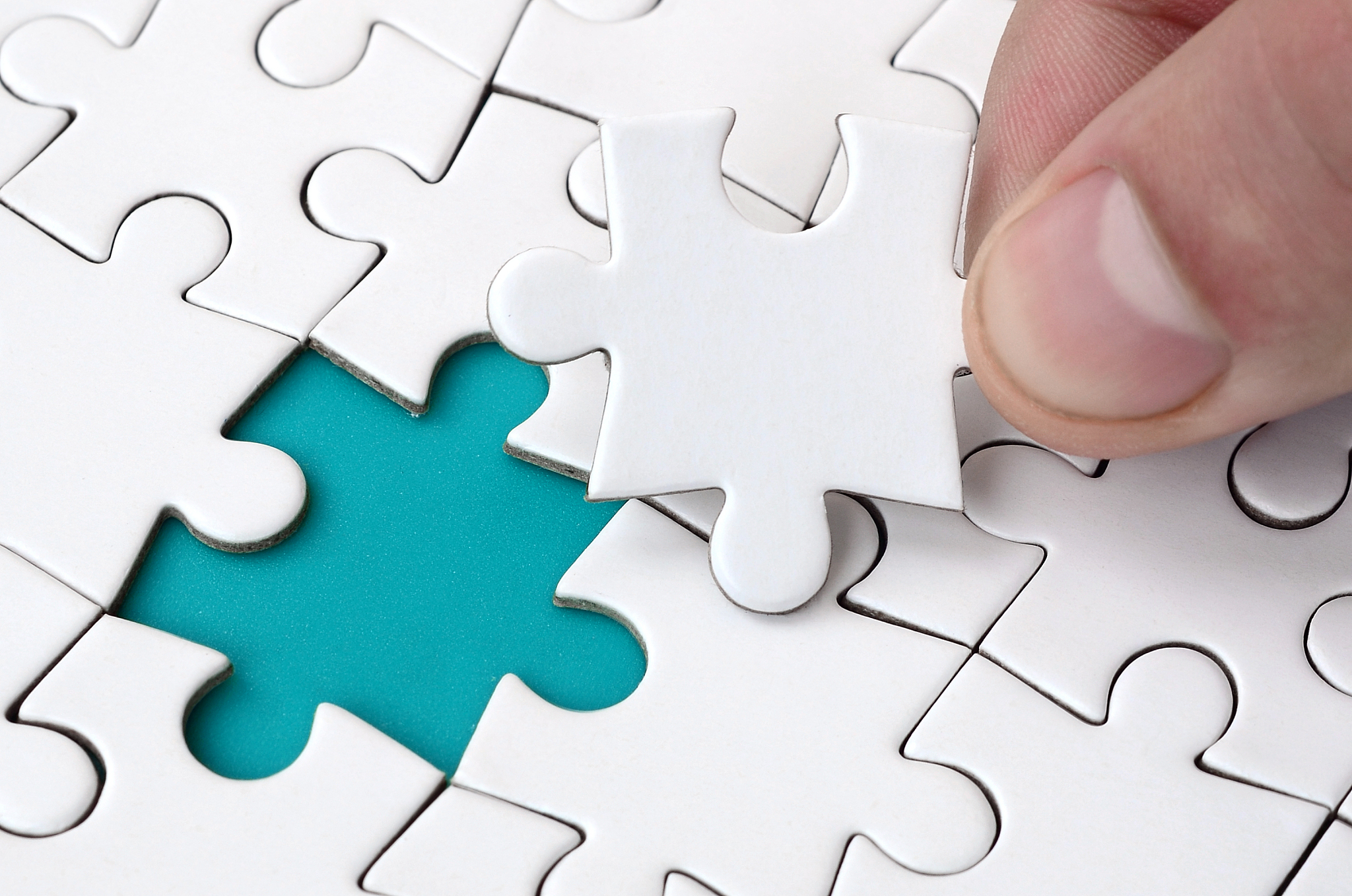 close-up of cropped hand holding puzzle piece