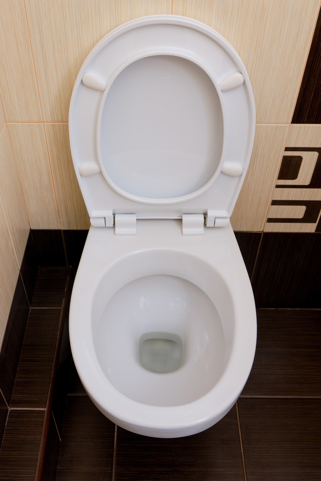 toilet with a raised seat on the background of abstract brown ti