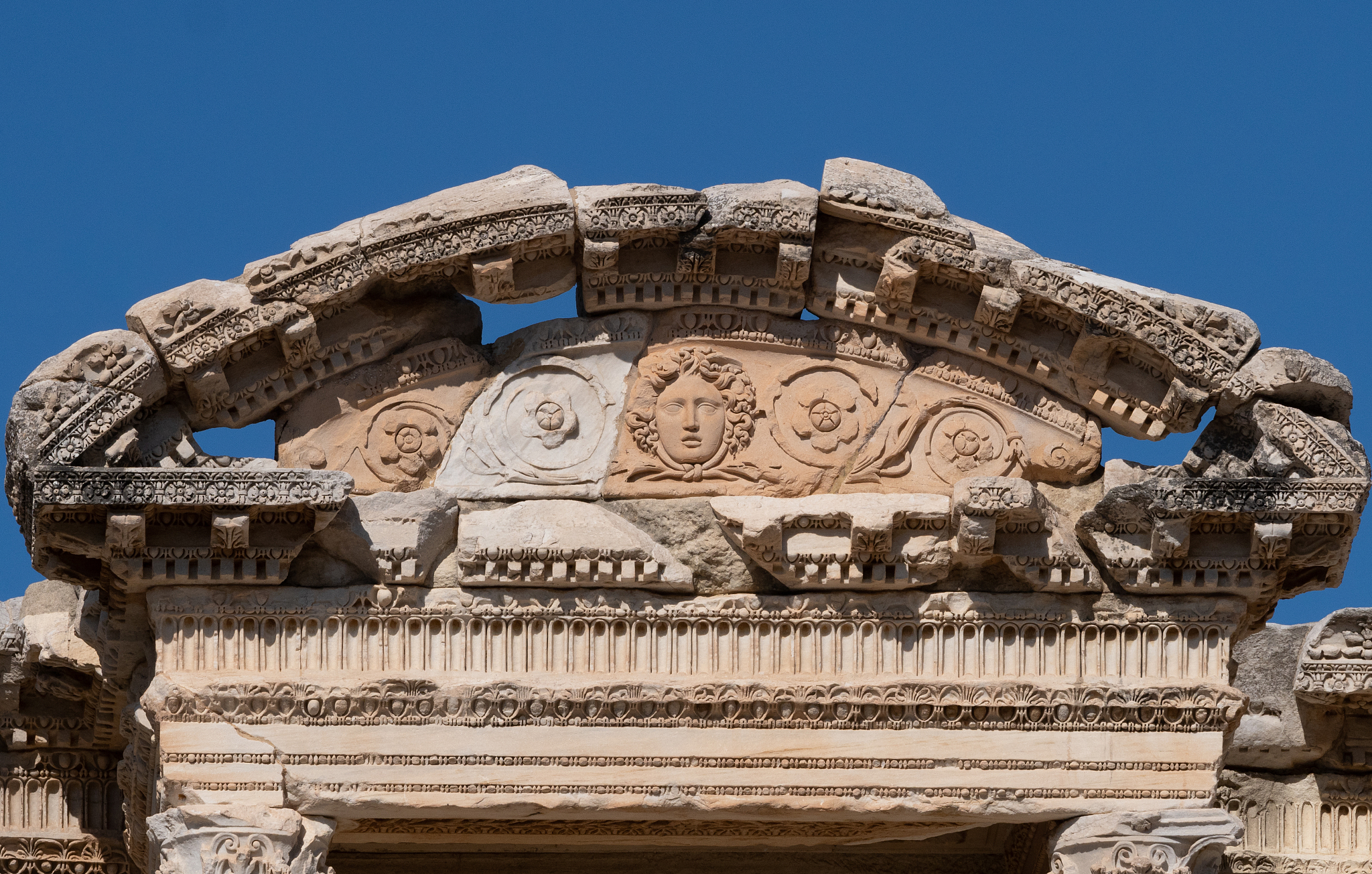 close up of the carved frieze with a face and flowers on the lib