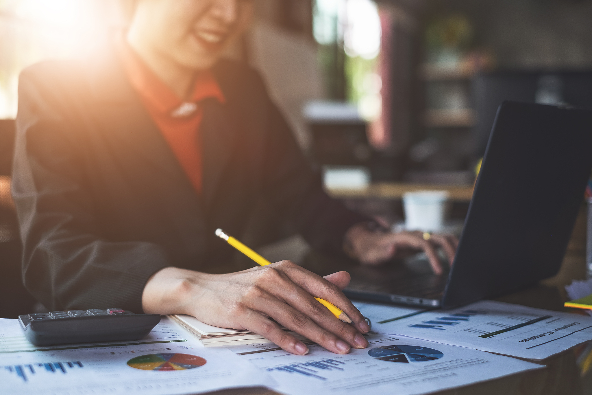 close up businesswoman hand holding pen and pointing at financia