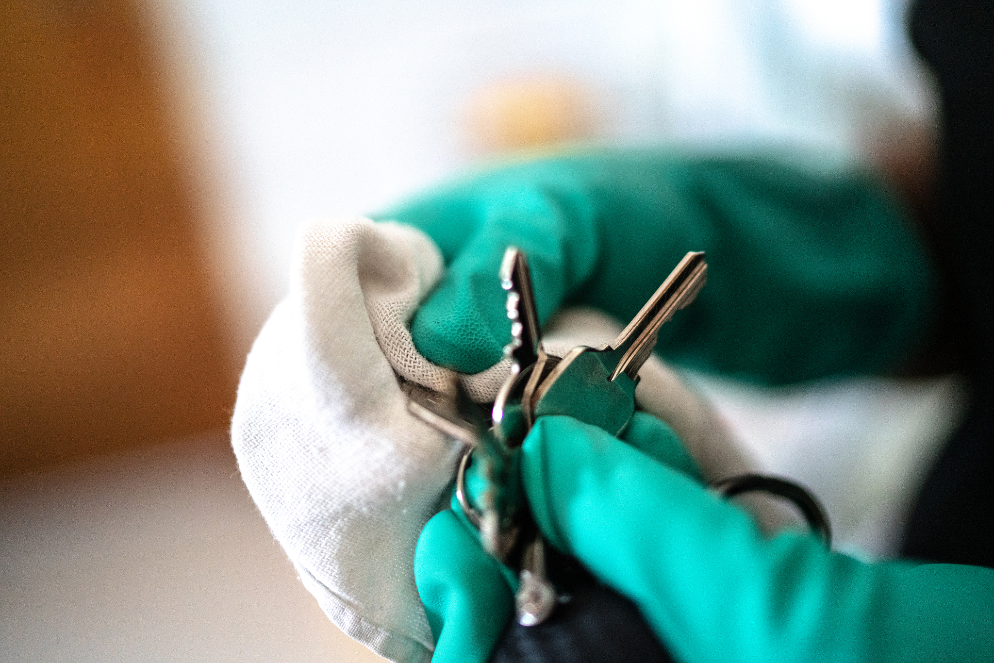 hands with glove cleaning car and house key