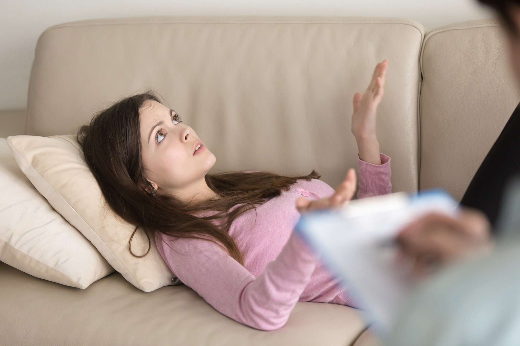 young woman lying on couch and talking, visit to psychologist