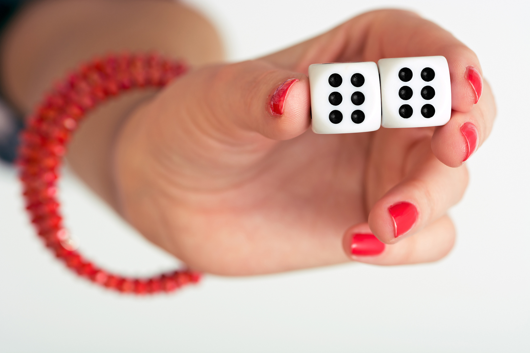 close up photo of a female hand holding two dices and showing do