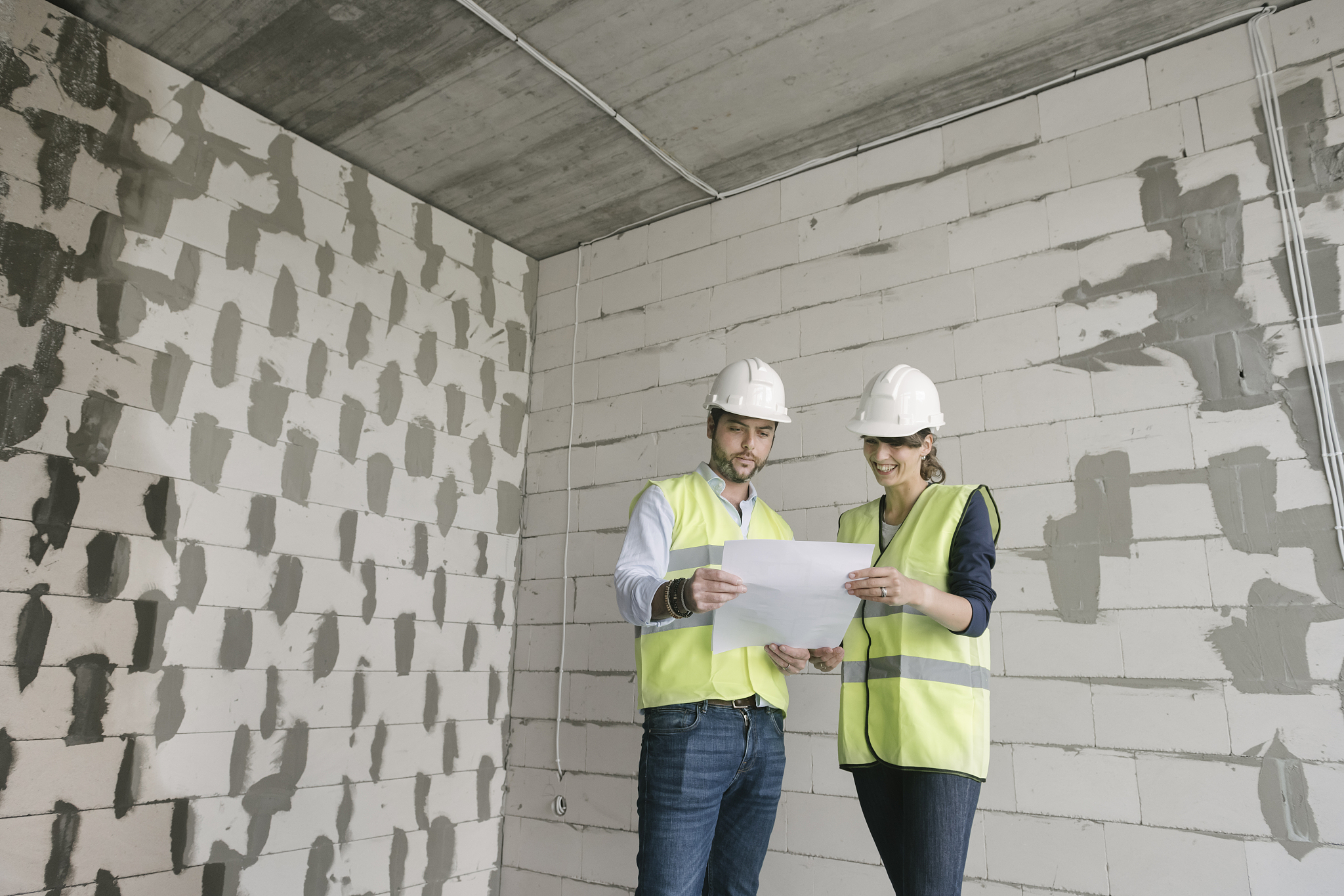 two architects talking while standing at construction site