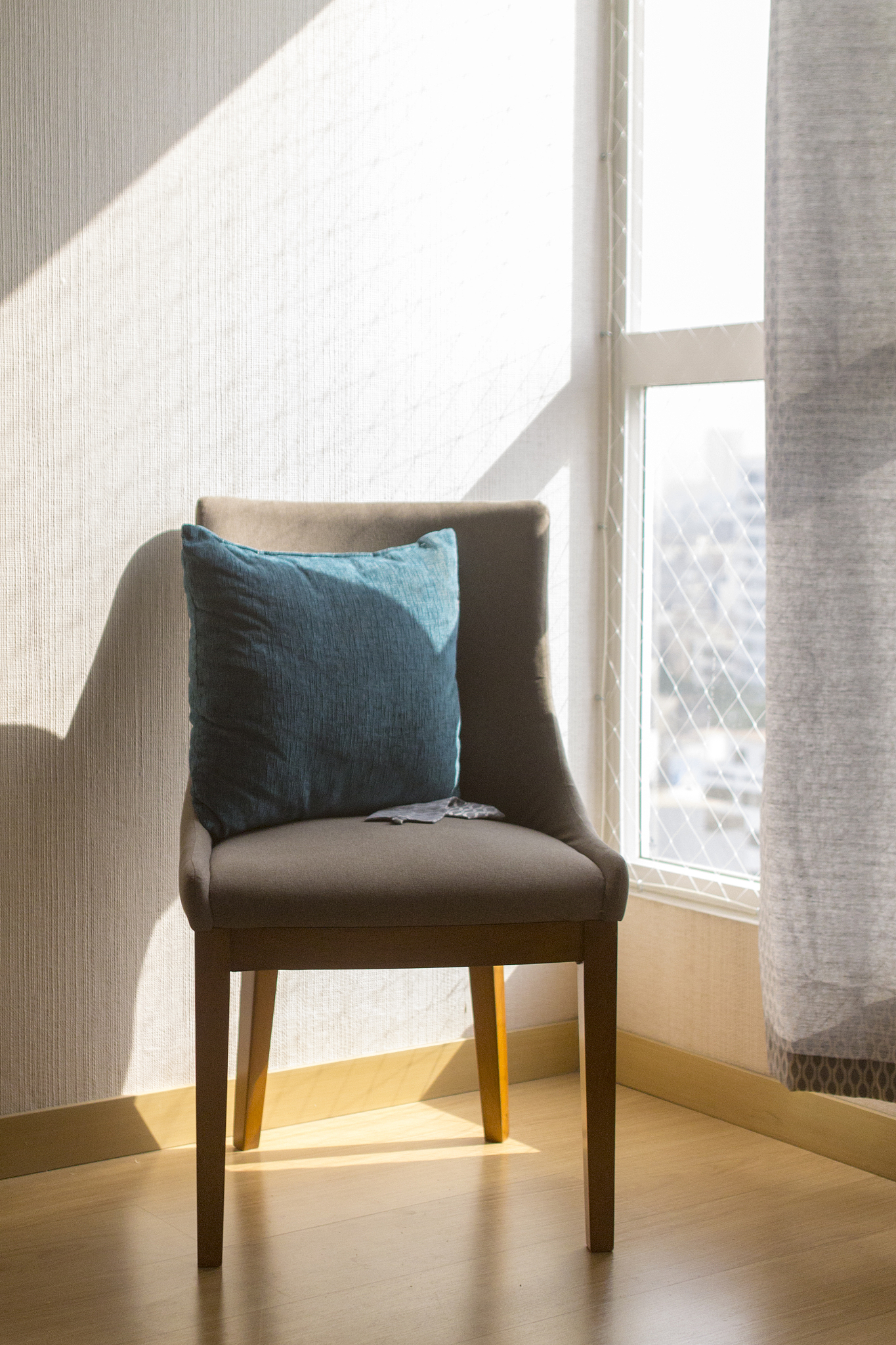 cushion on chair by window at home