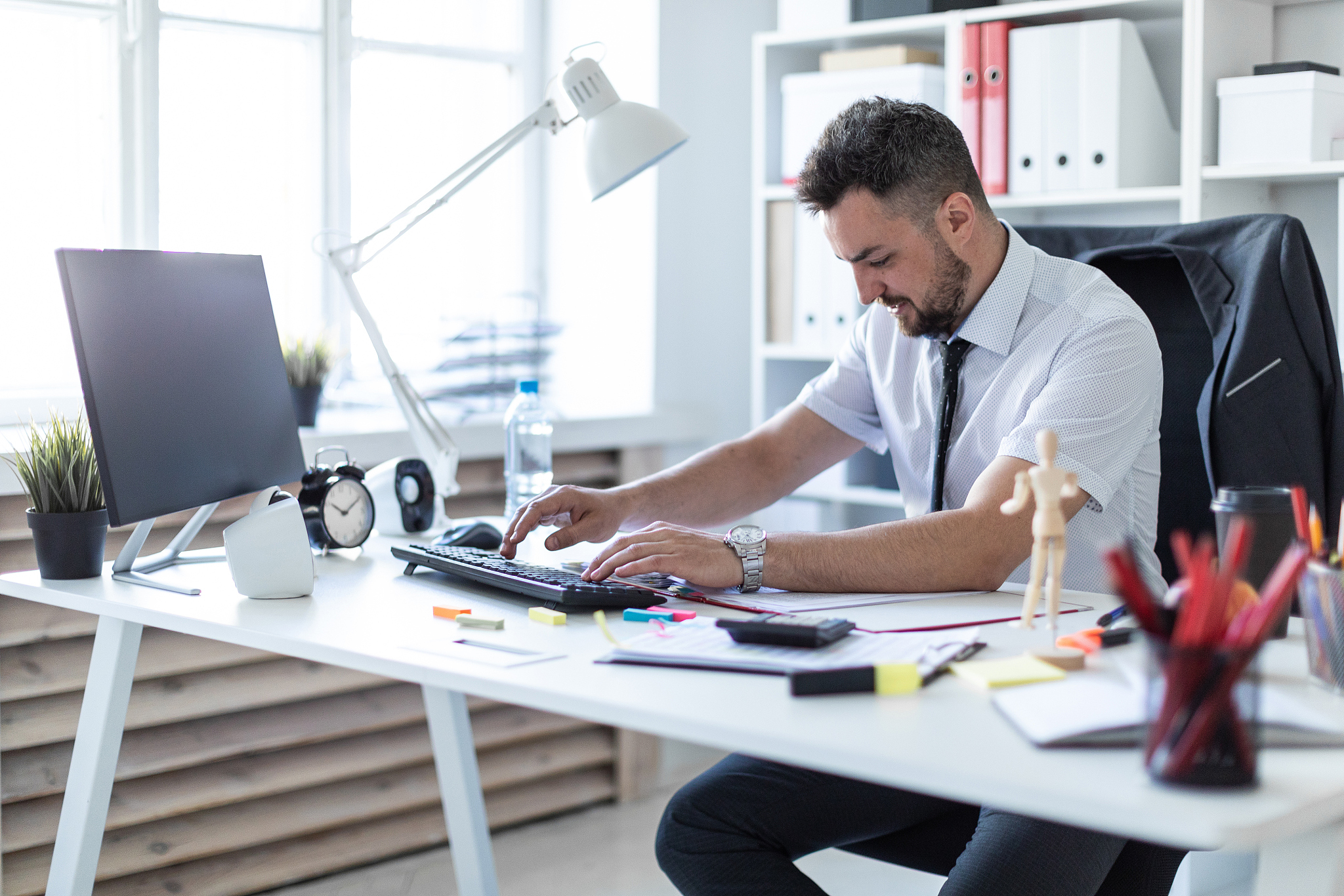 a man is sitting at a table in the office, working with document