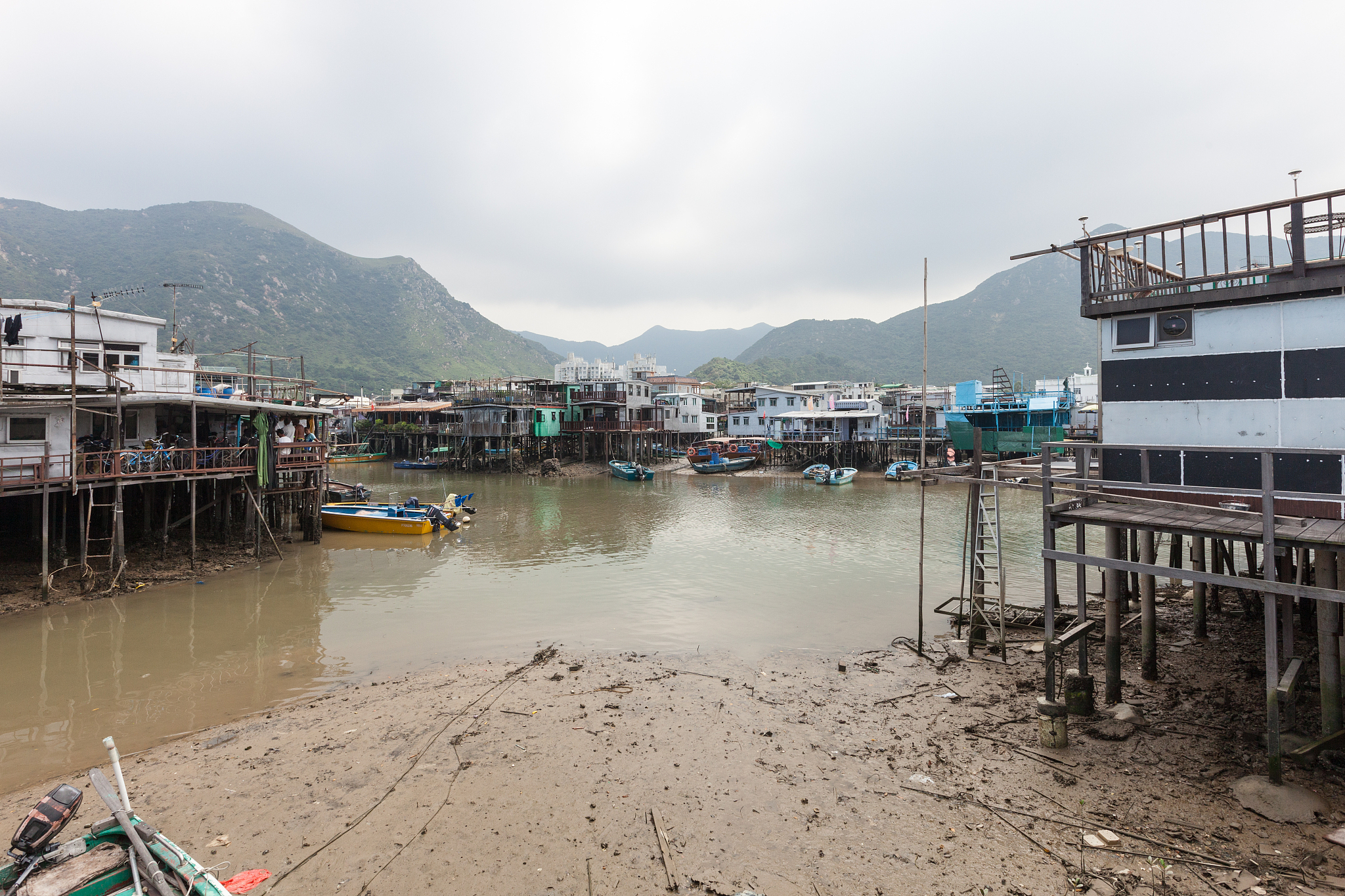 boats beached nearby stilt houses in the fishing village of tai 