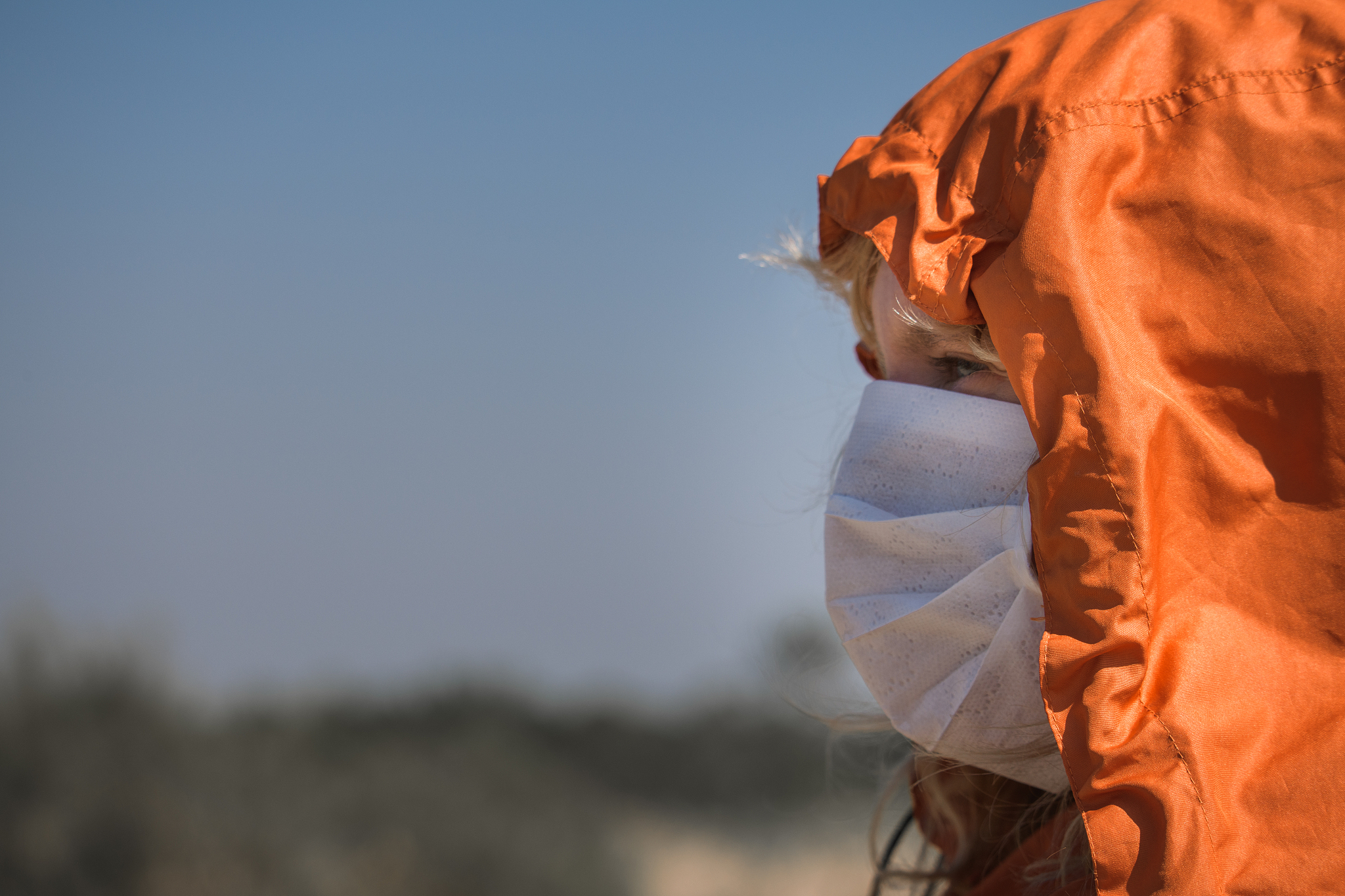lonely girl with a mask on the beach during coronavirus epidemic