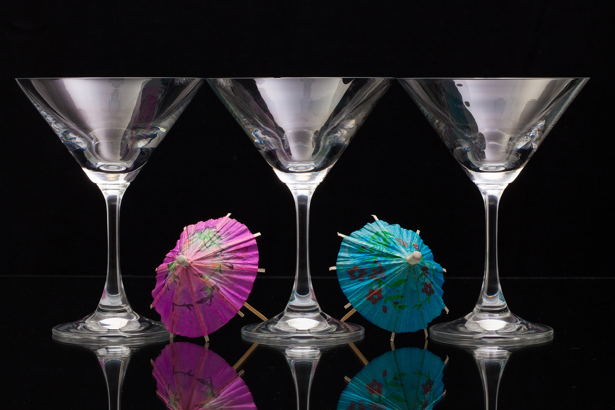 three empty glasses of champagne with paper umbrellas