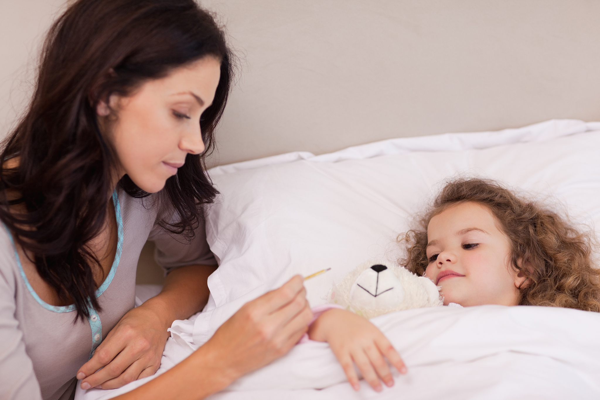 mother taking her daughters temperature