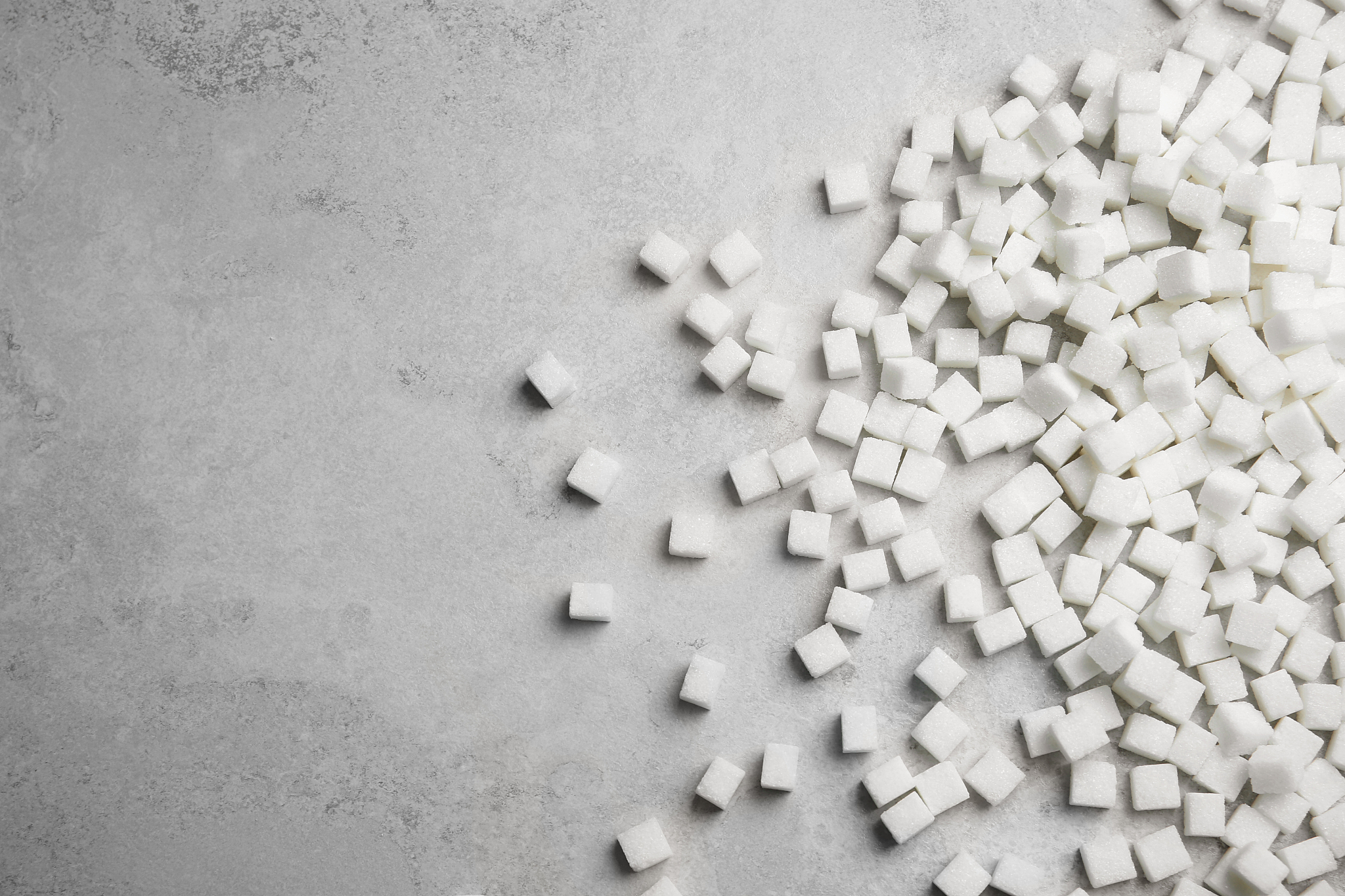 refined sugar cubes on grey background, top view