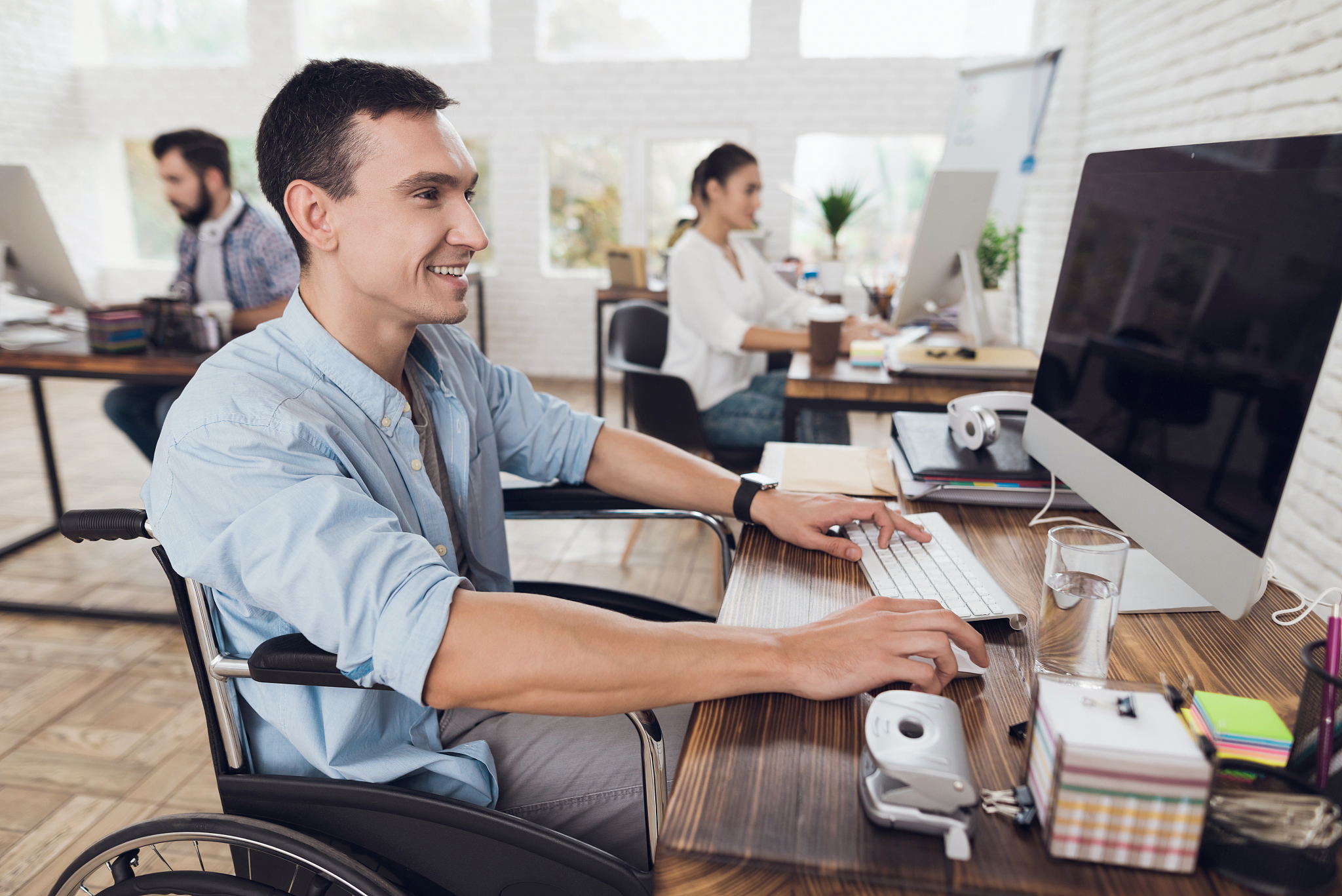 disabled person in the wheelchair works in the office at the com